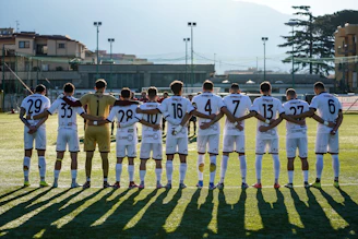 Soccer team stands with arms around shoulders on field