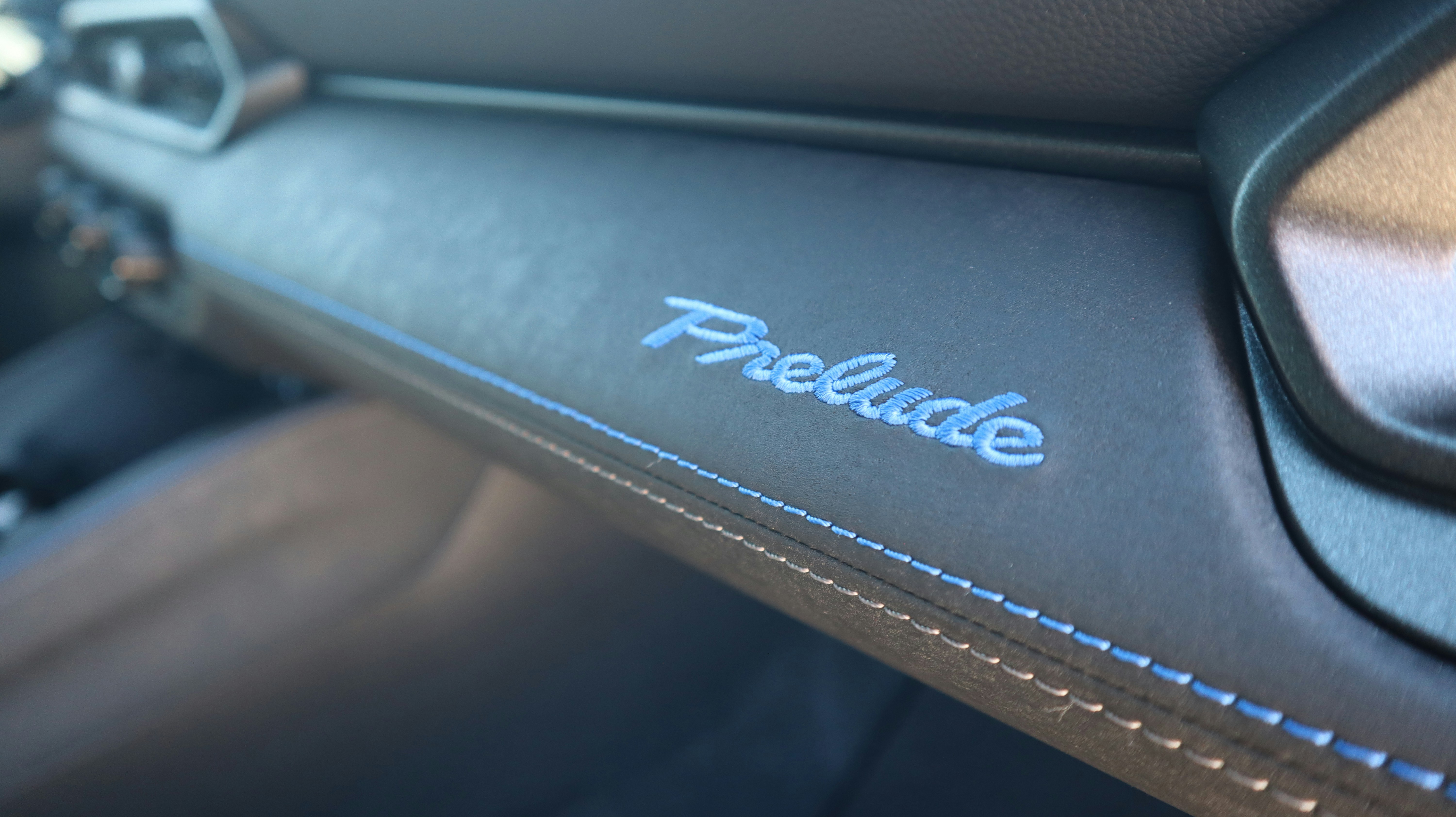 Close-up of 'prelude' emblem on car dashboard