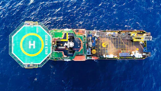 Aerial view of a large ship with helipad at sea