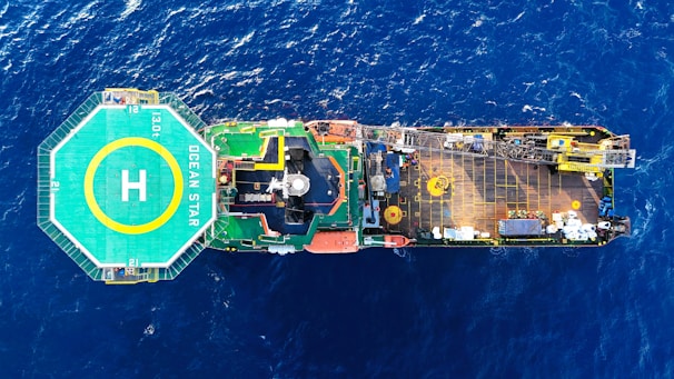 Aerial view of a large ship with helipad at sea