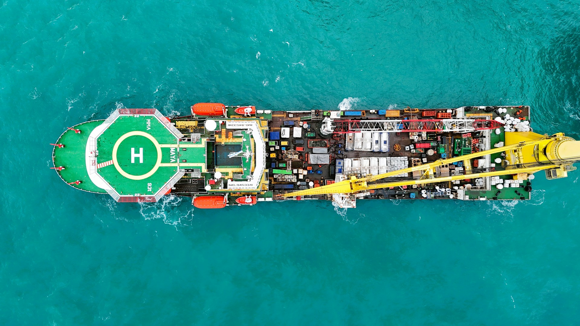 Aerial view of a large industrial ship with a helipad.