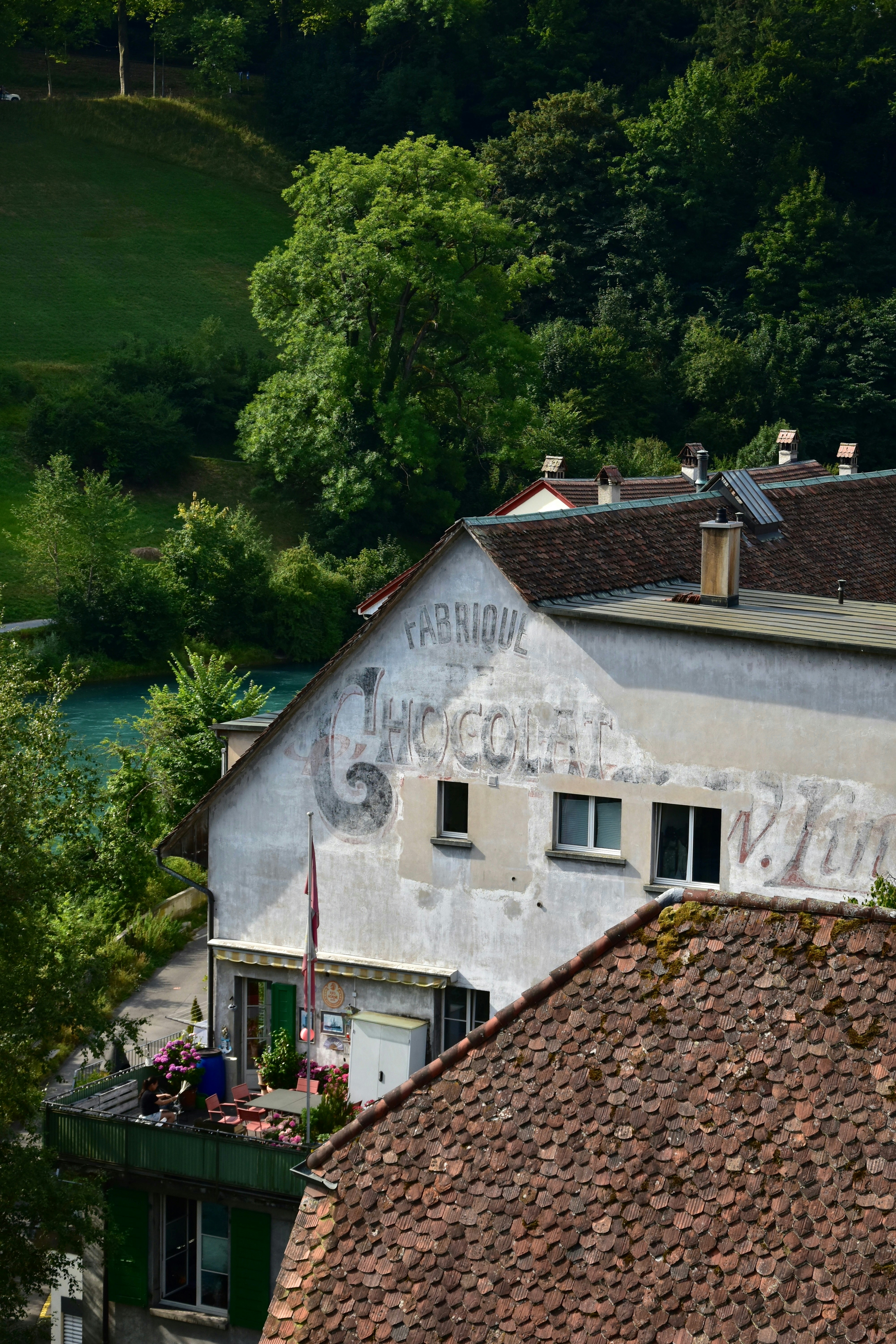 Old factory building with tiled roof and balcony.