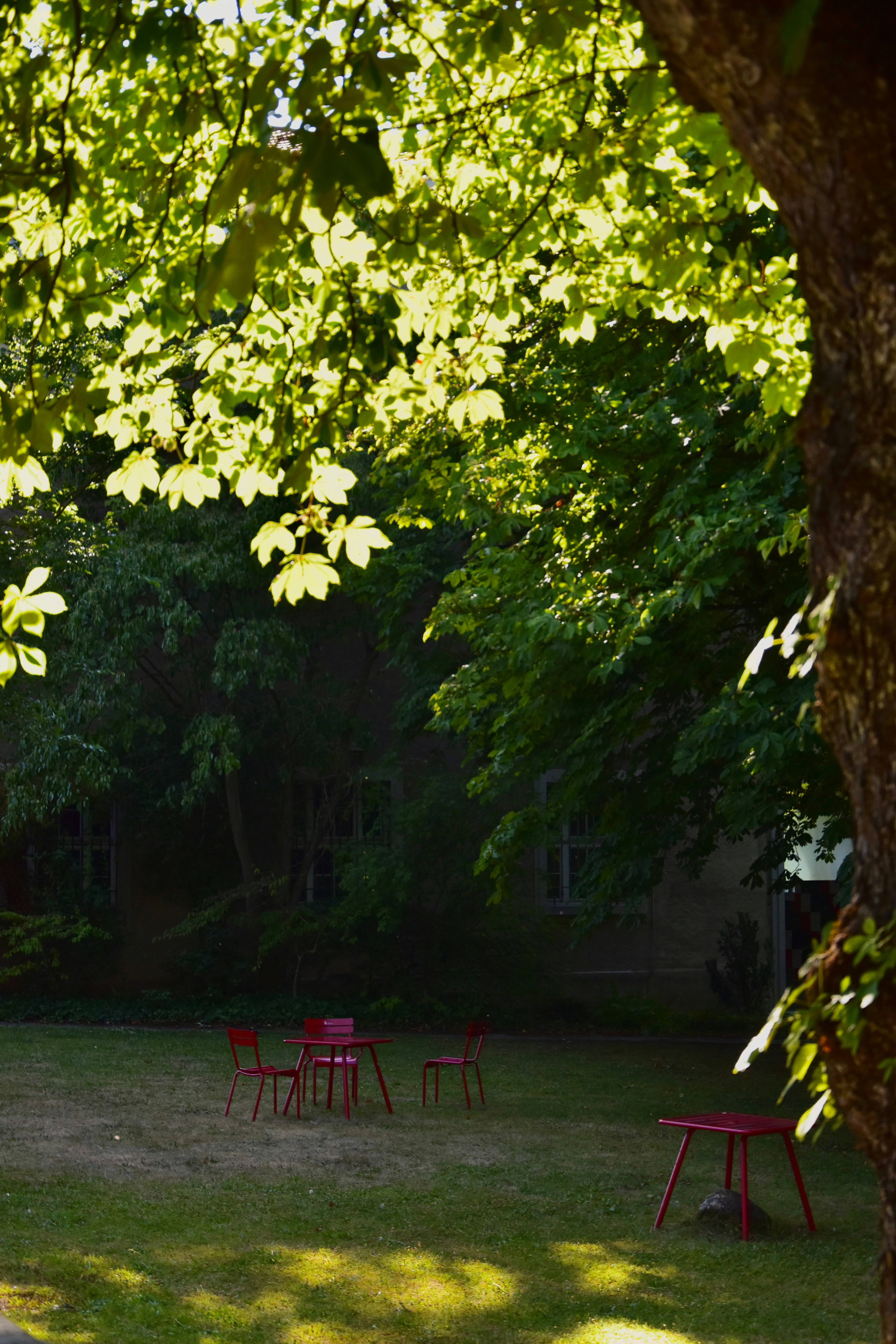 Red chairs and table in a sunlit garden