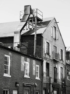 Brick buildings with industrial pipework against sky