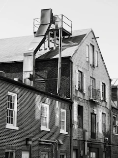 Brick buildings with industrial pipework against sky