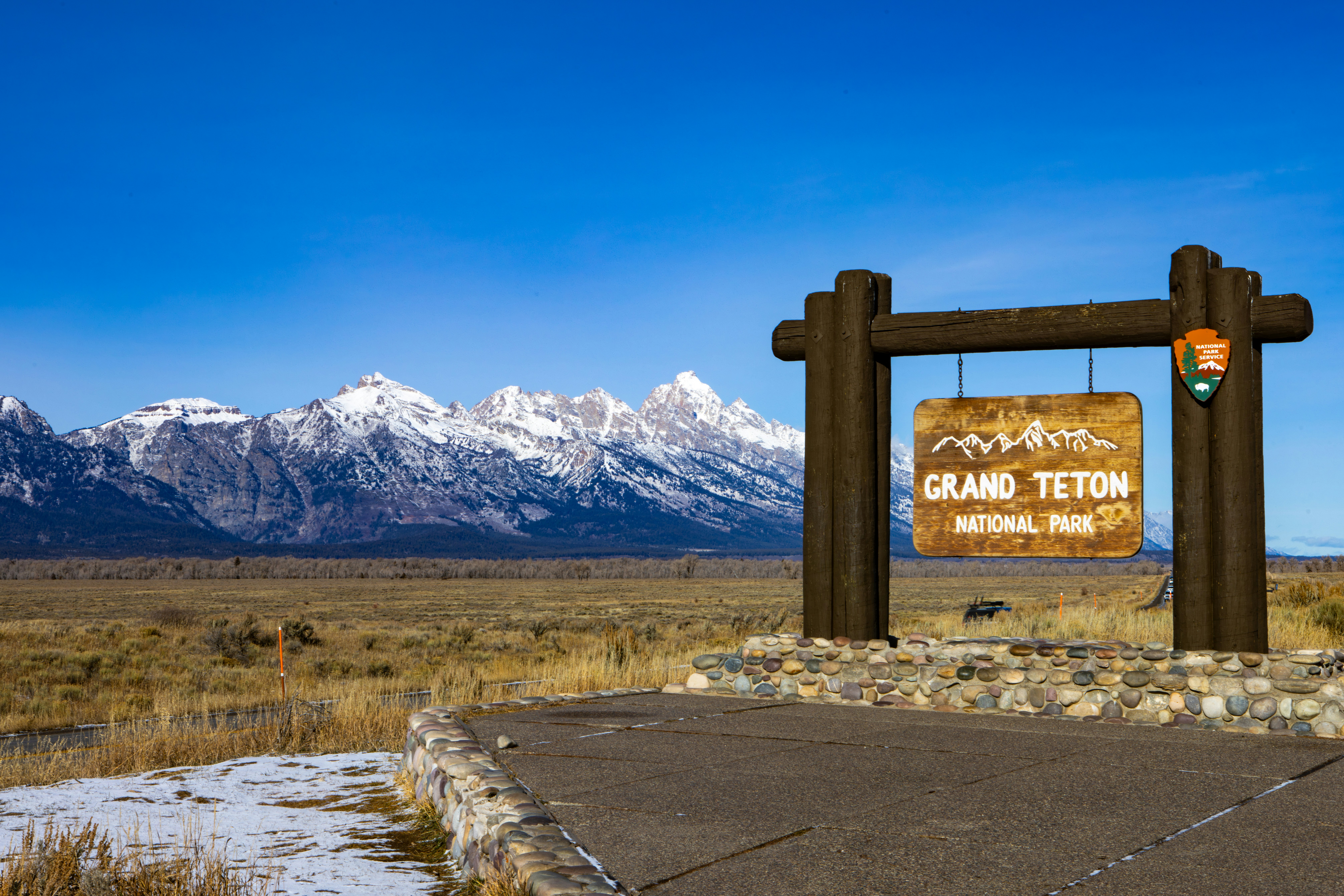 Grand teton national park entrance sign with mountains