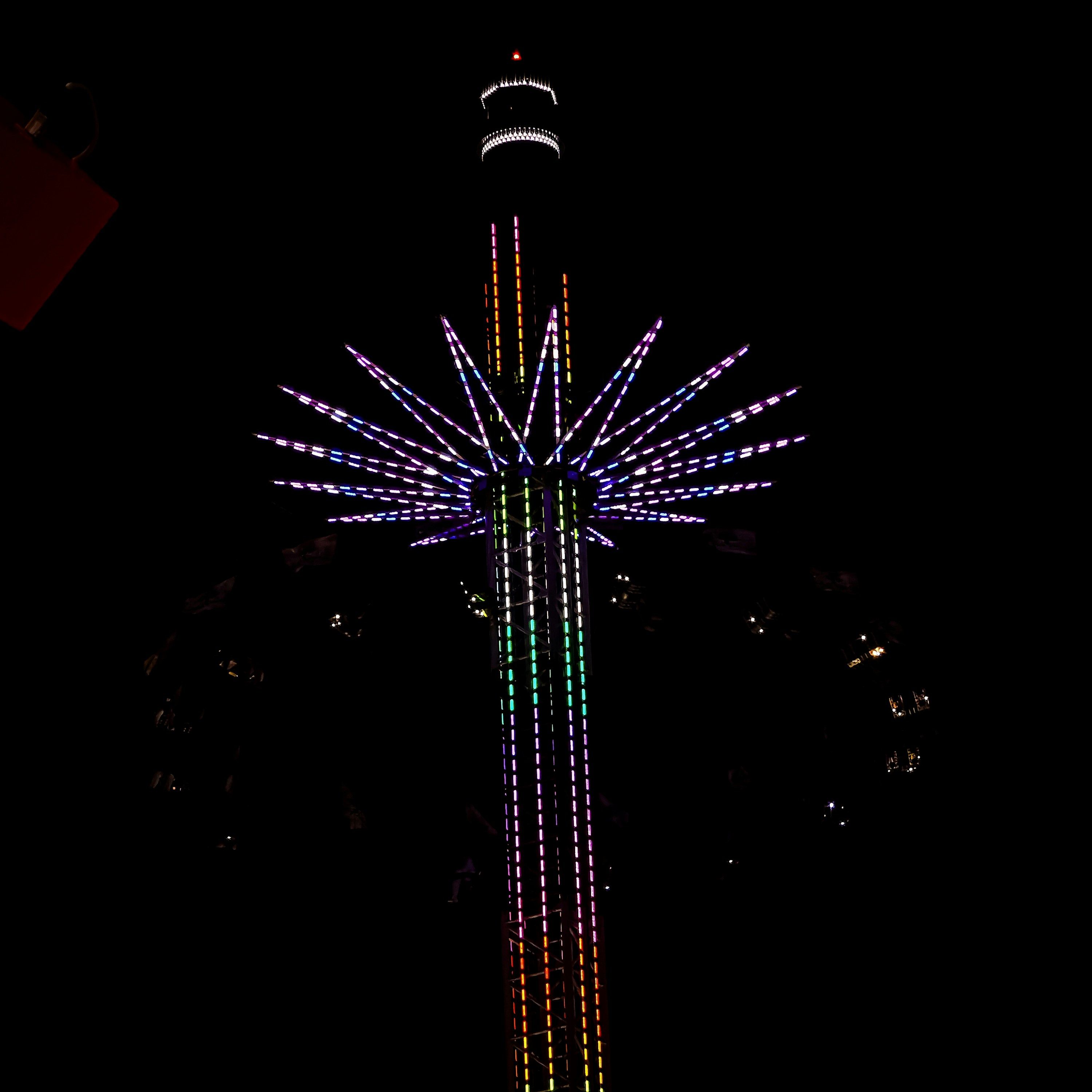 Brinquedo alto de parque de diversões iluminado à noite