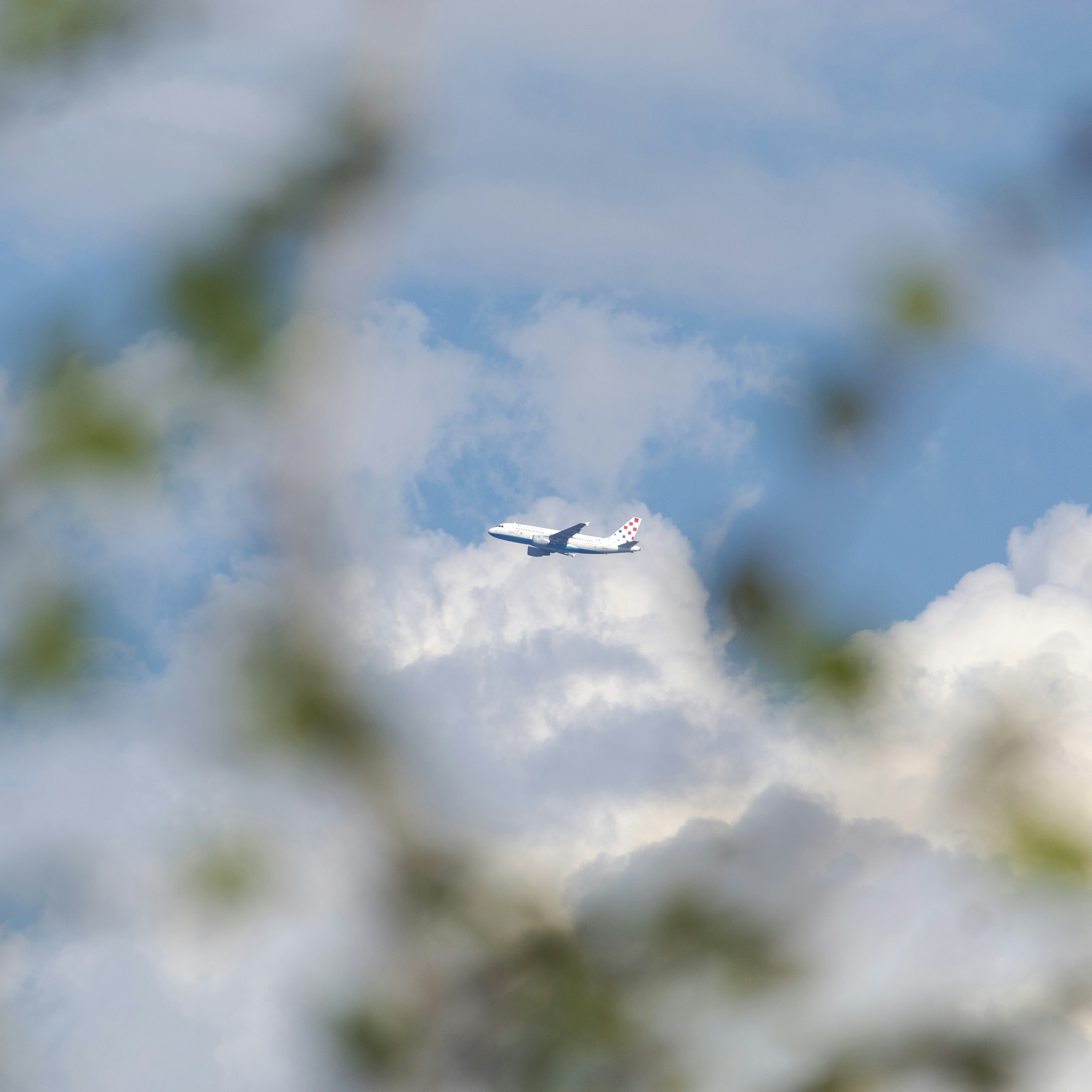 An airplane flying through clouds in the sky.