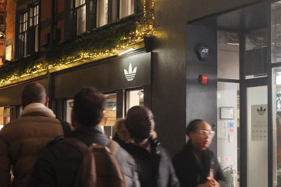 People walking past an Adidas store at night