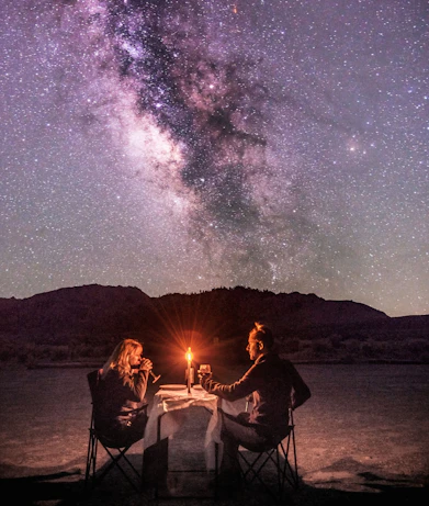 Couple dining under the milky way galaxy