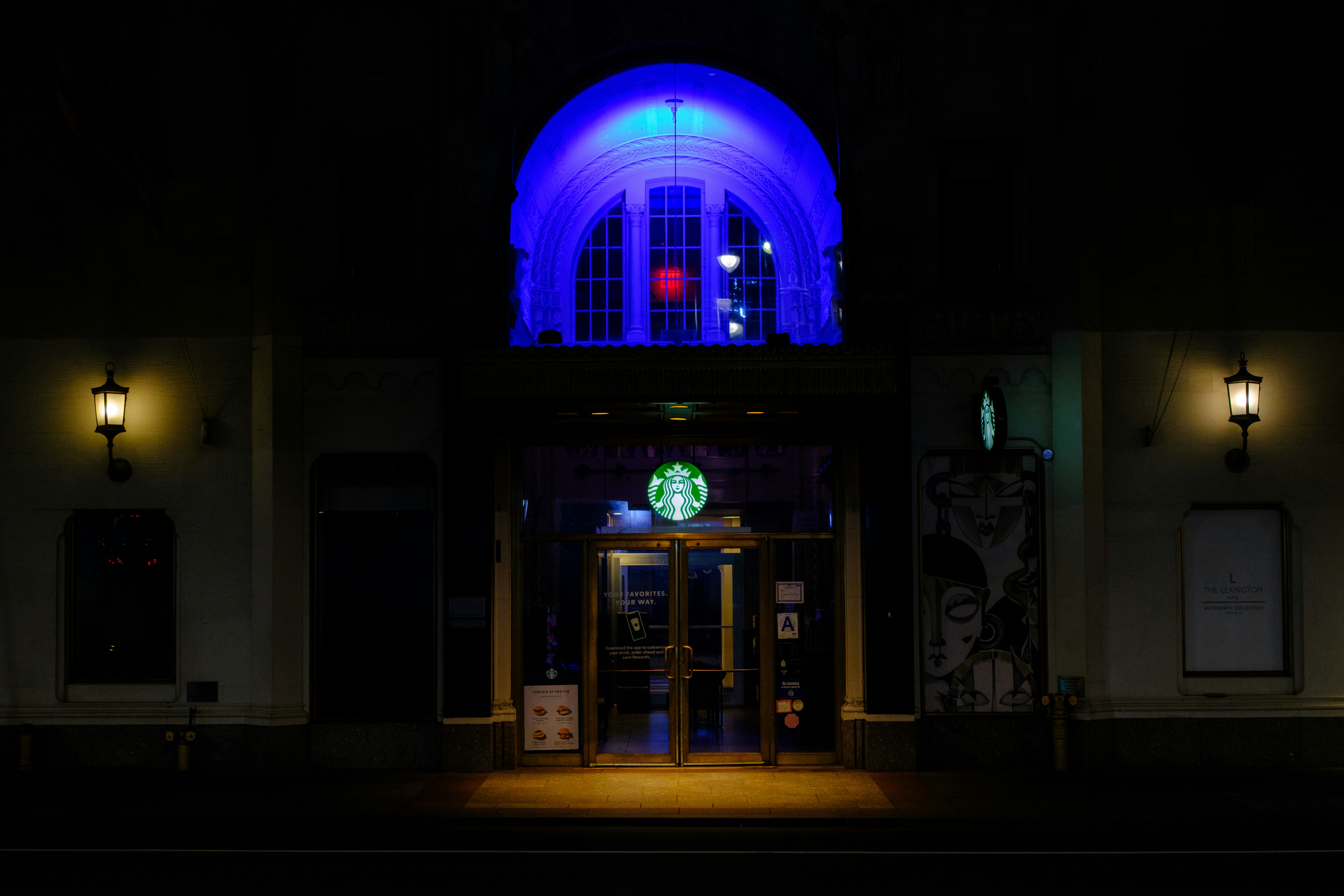 Starbucks store entrance illuminated at night with blue light