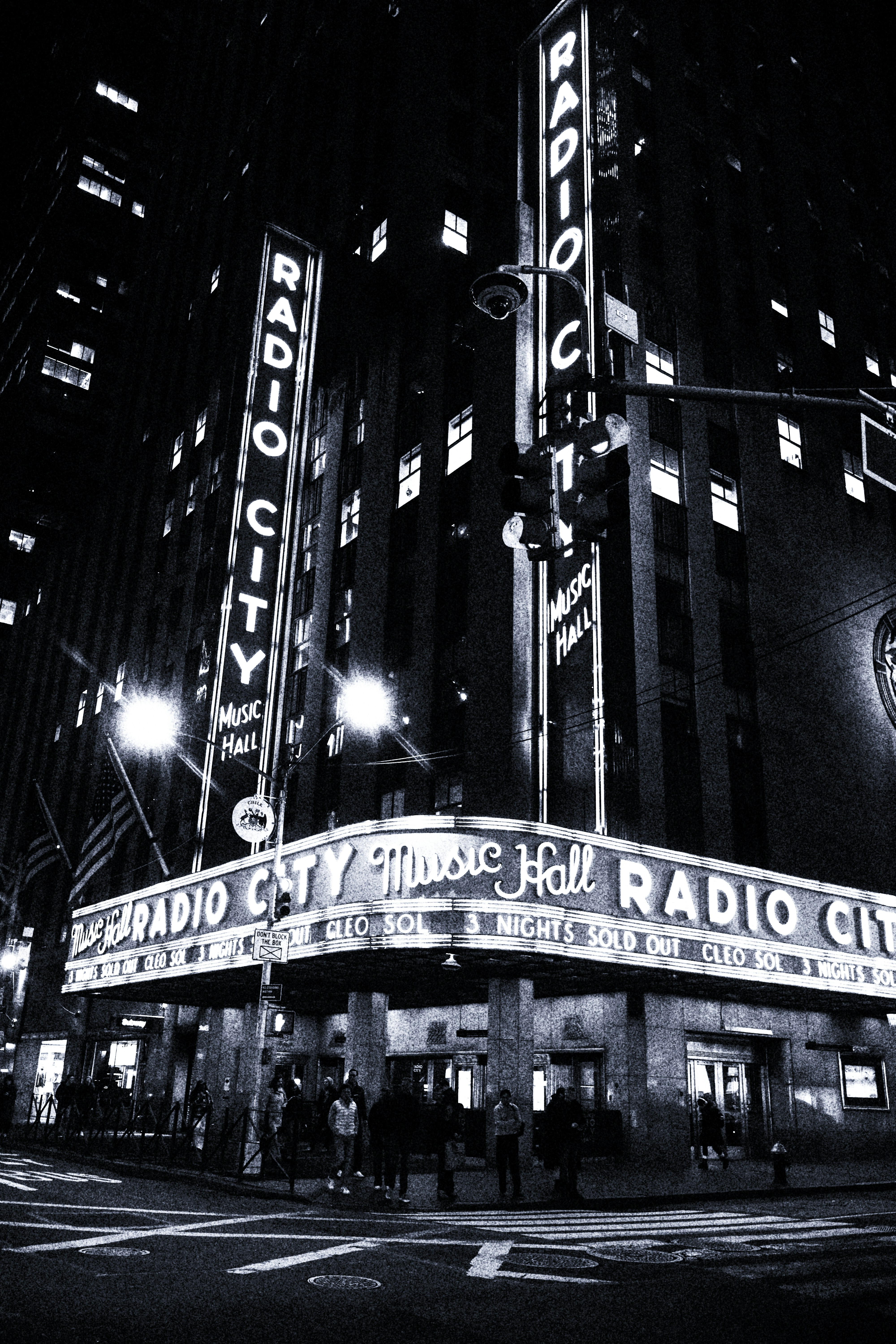 Radio city music hall building at night with neon signs.