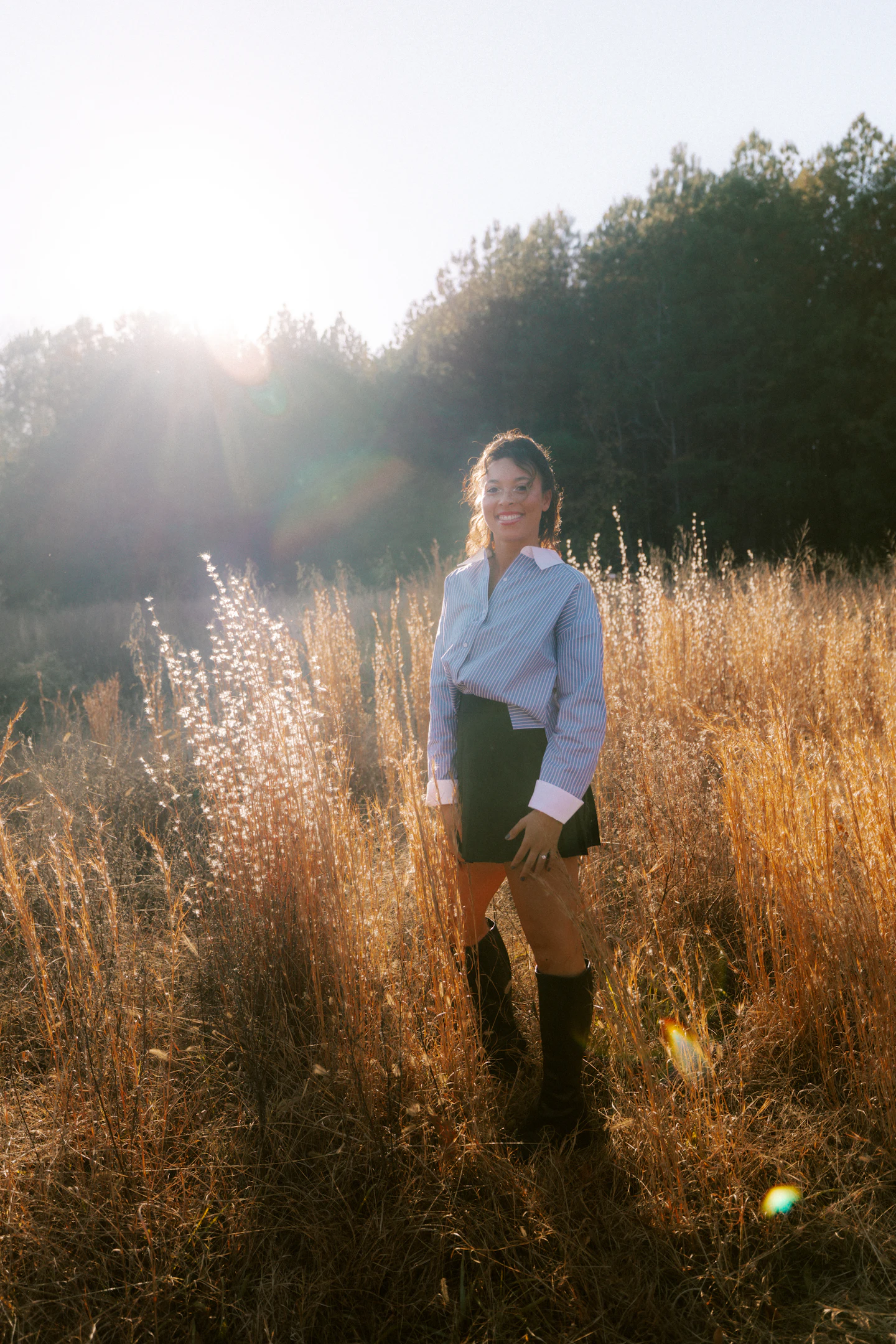 Standing in tall dry grass at sunset