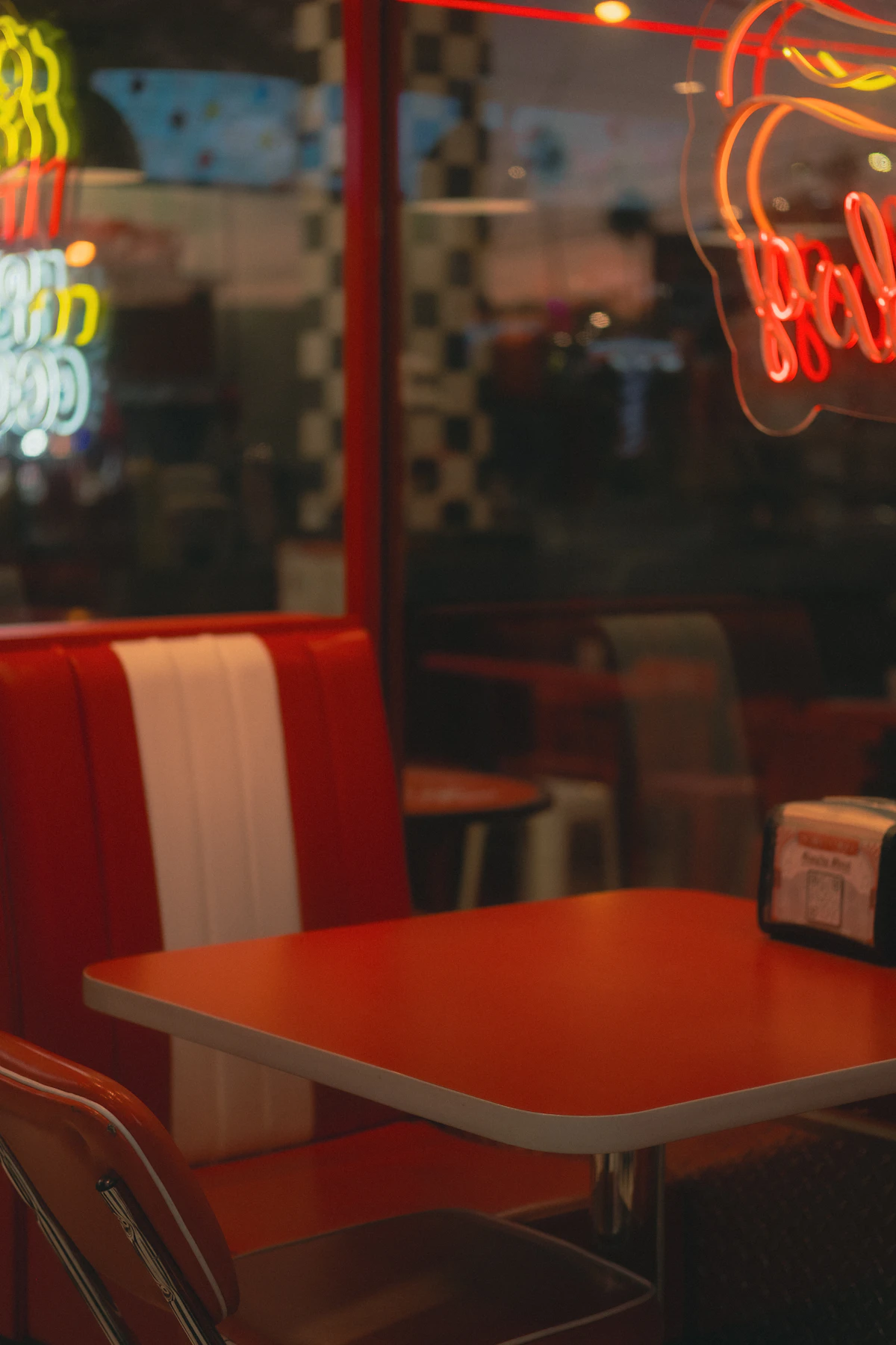 Mesa vacía de un diner iluminada por luces de neón, imagen de la soledad en los relatos de Raymond Carver