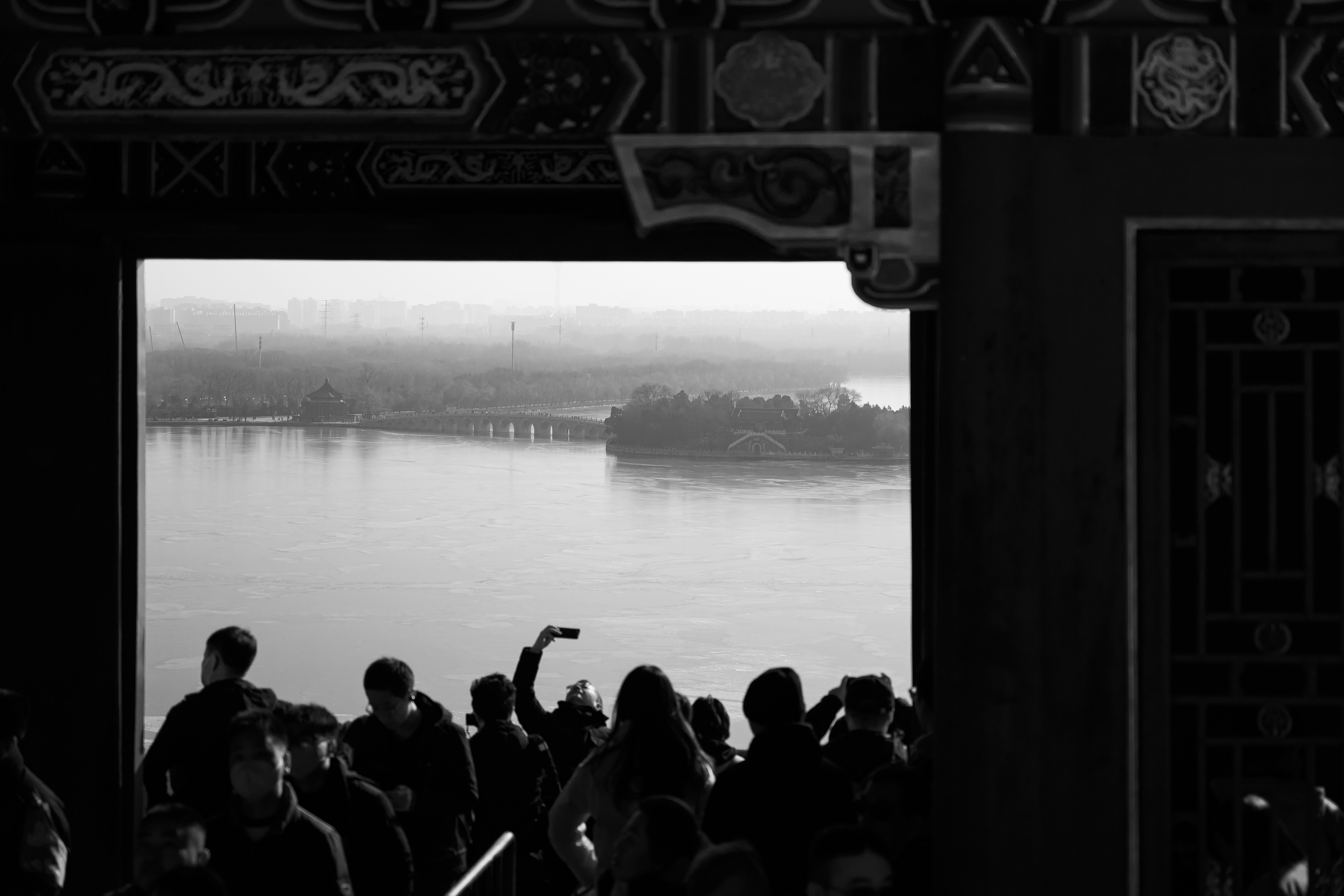 People silhouetted against a hazy lake view.