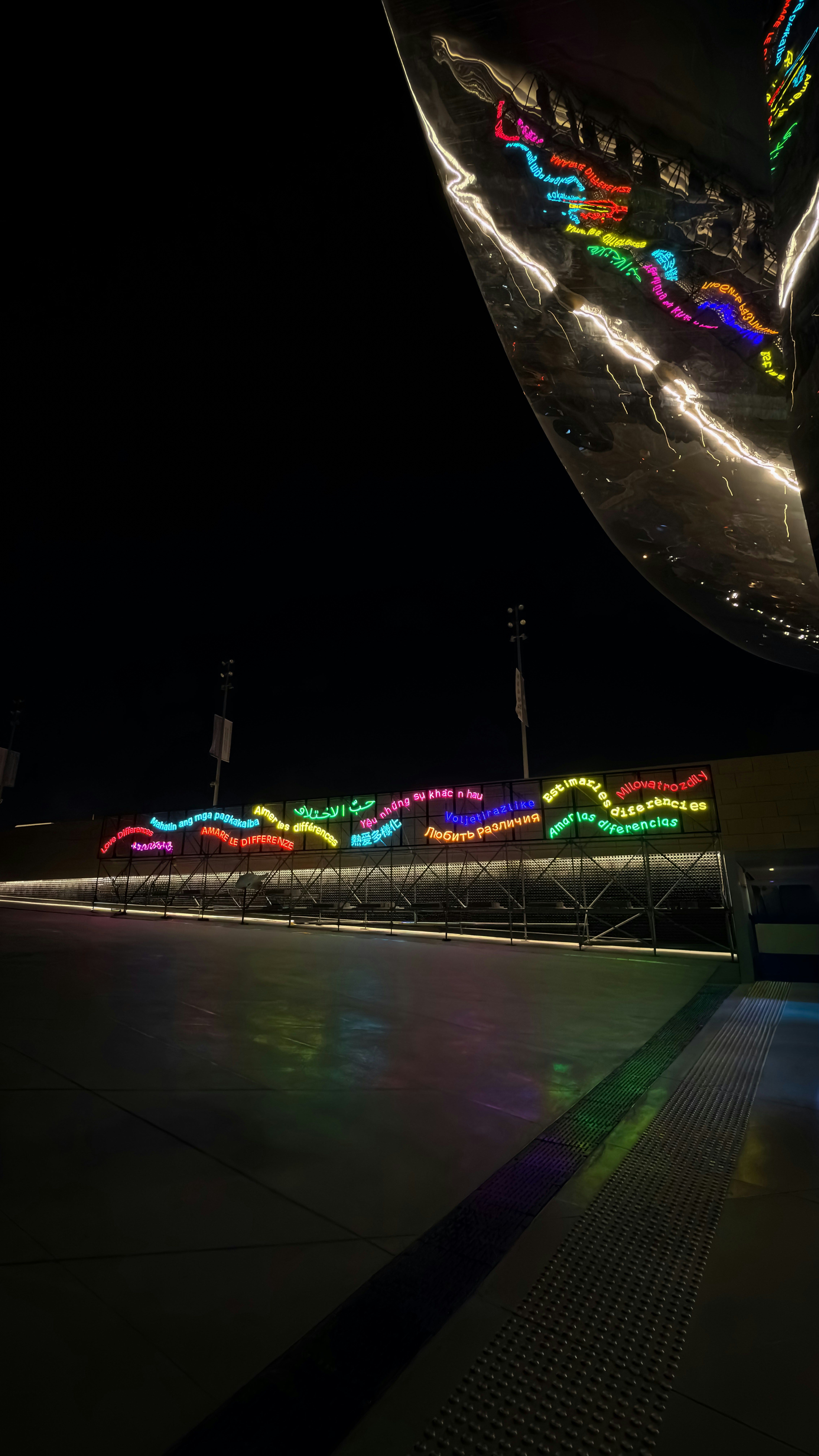 Luces onduladas de colores iluminan un pasillo oscuro por la noche.