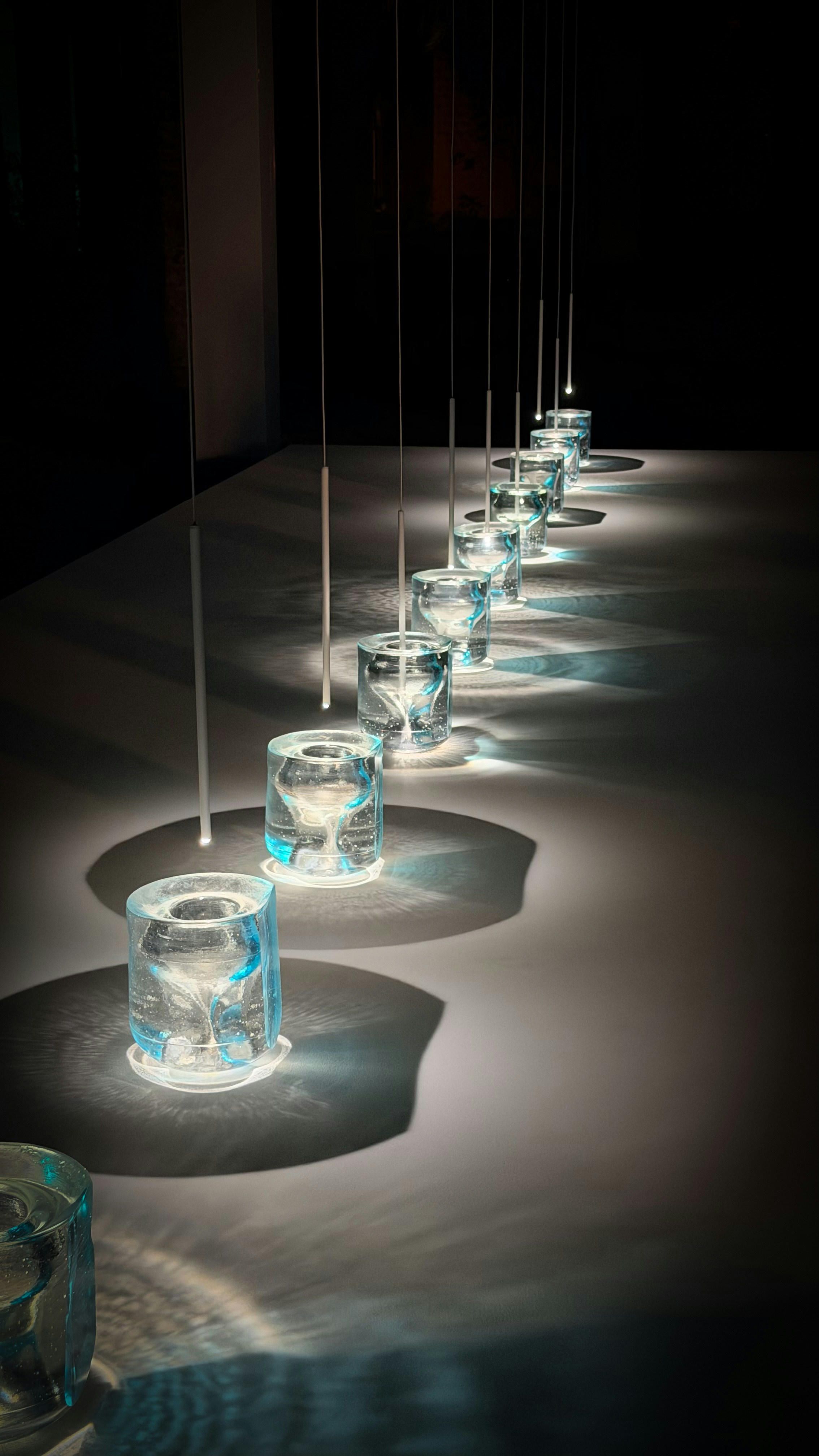 Fila de vasos transparentes con agua y luces