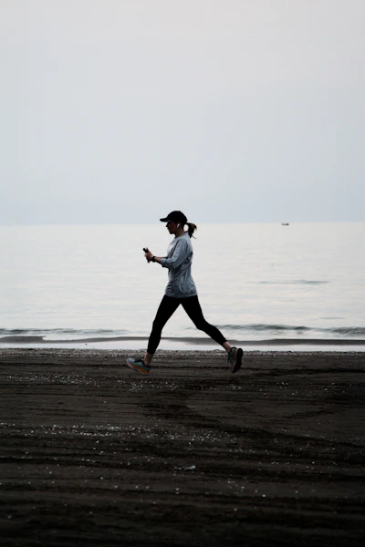 Woman jogging on a dark beach near the ocean