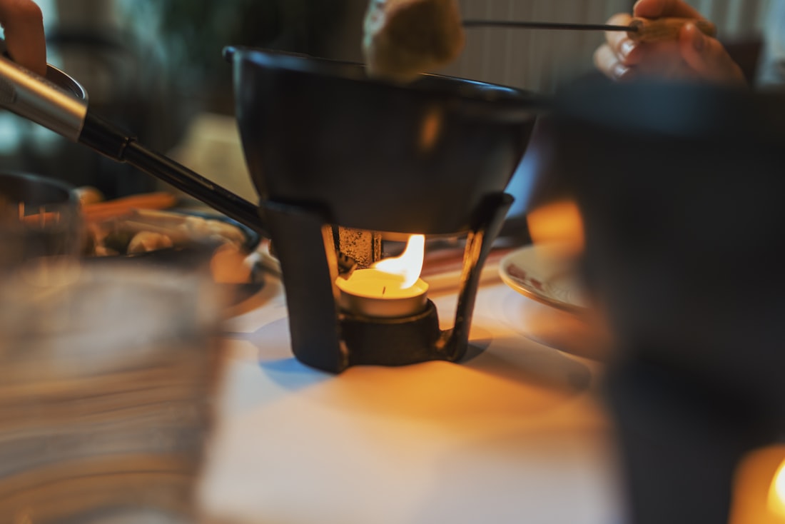 Caquelon à fondue posé sur un réchaud allumé