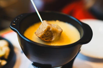 A piece of bread dipped in cheese fondue