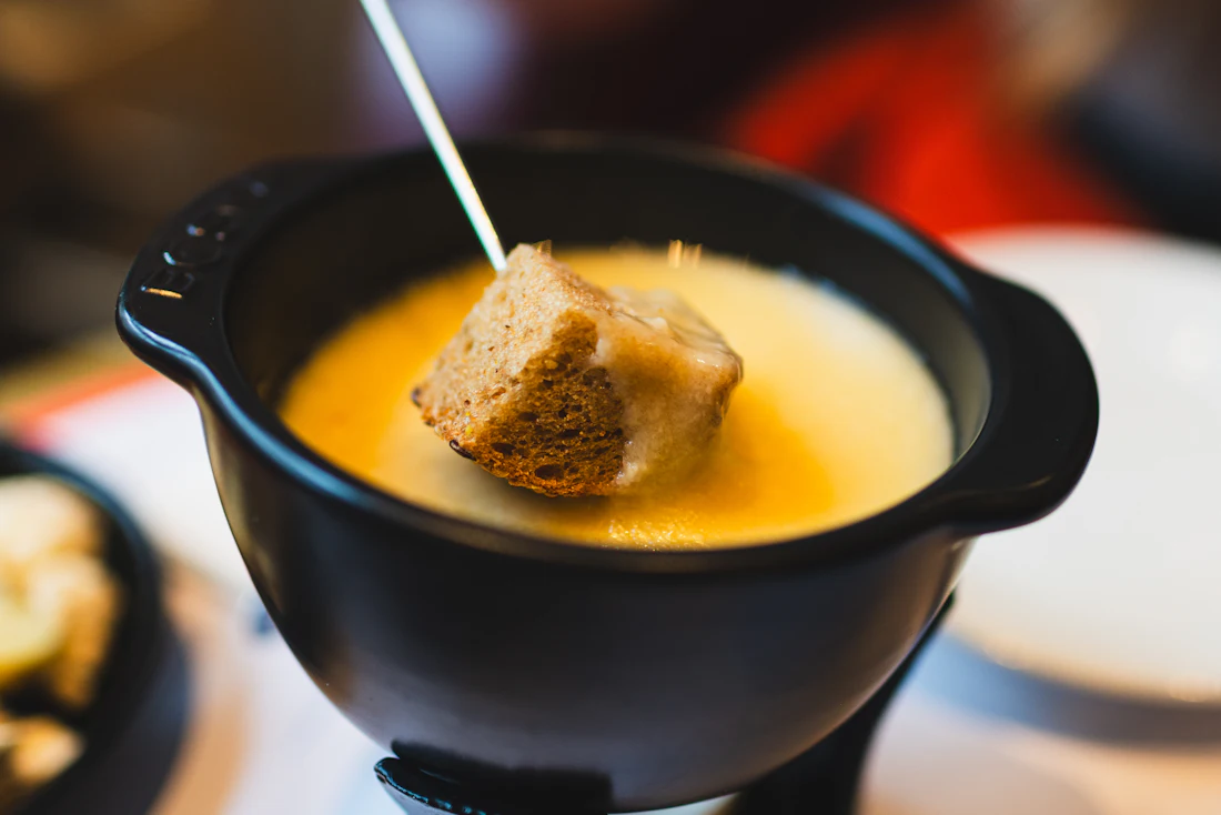Een stukje brood gedoopt in kaasfondue