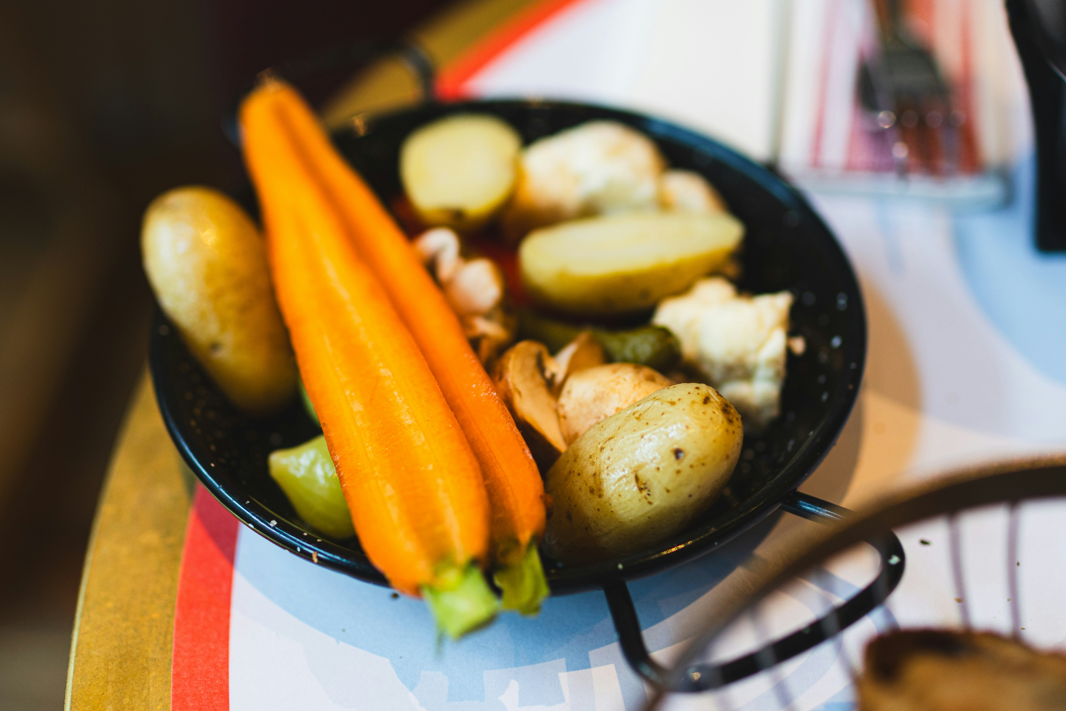 A dish of roasted vegetables with carrots and potatoes.