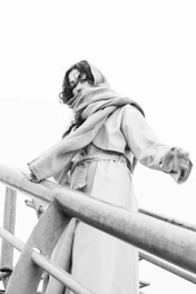 Woman in trench coat and scarf on stairs
