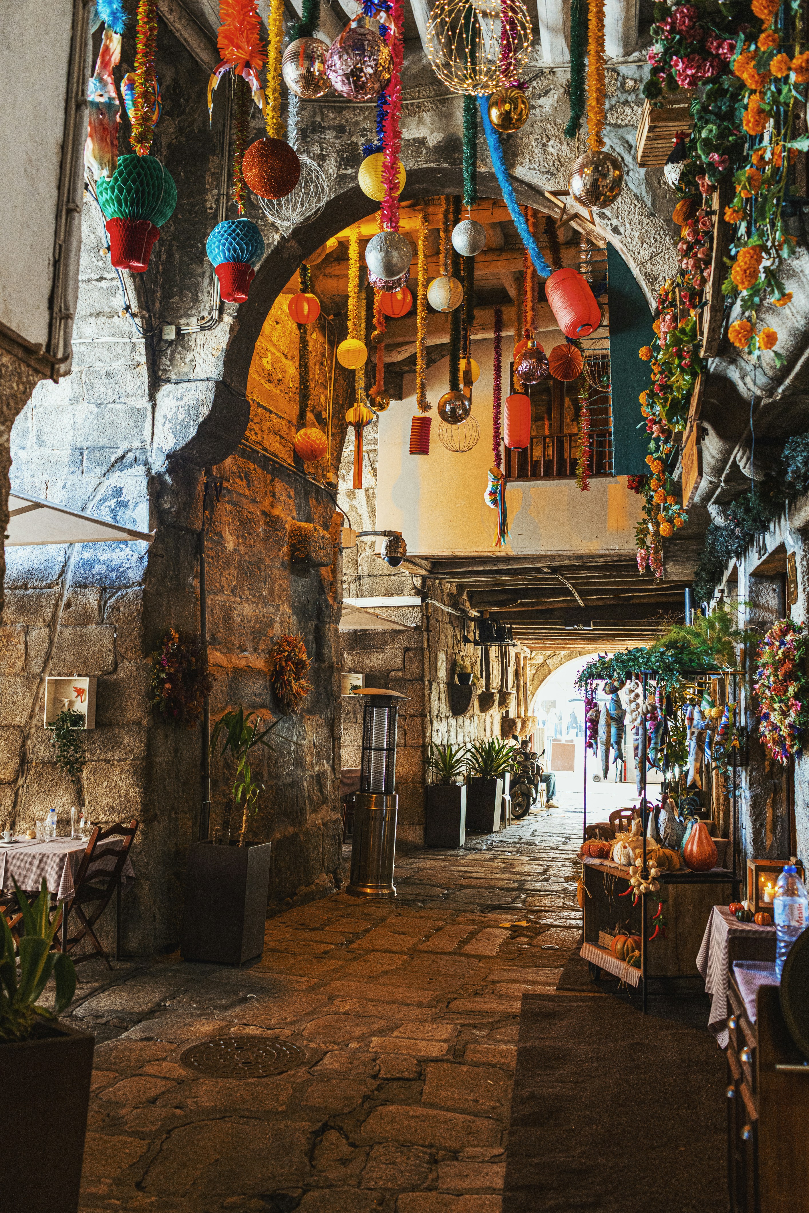 Eine kunstvolle Gasse, geschmückt mit bunten, hängenden Ornamenten und Blumen