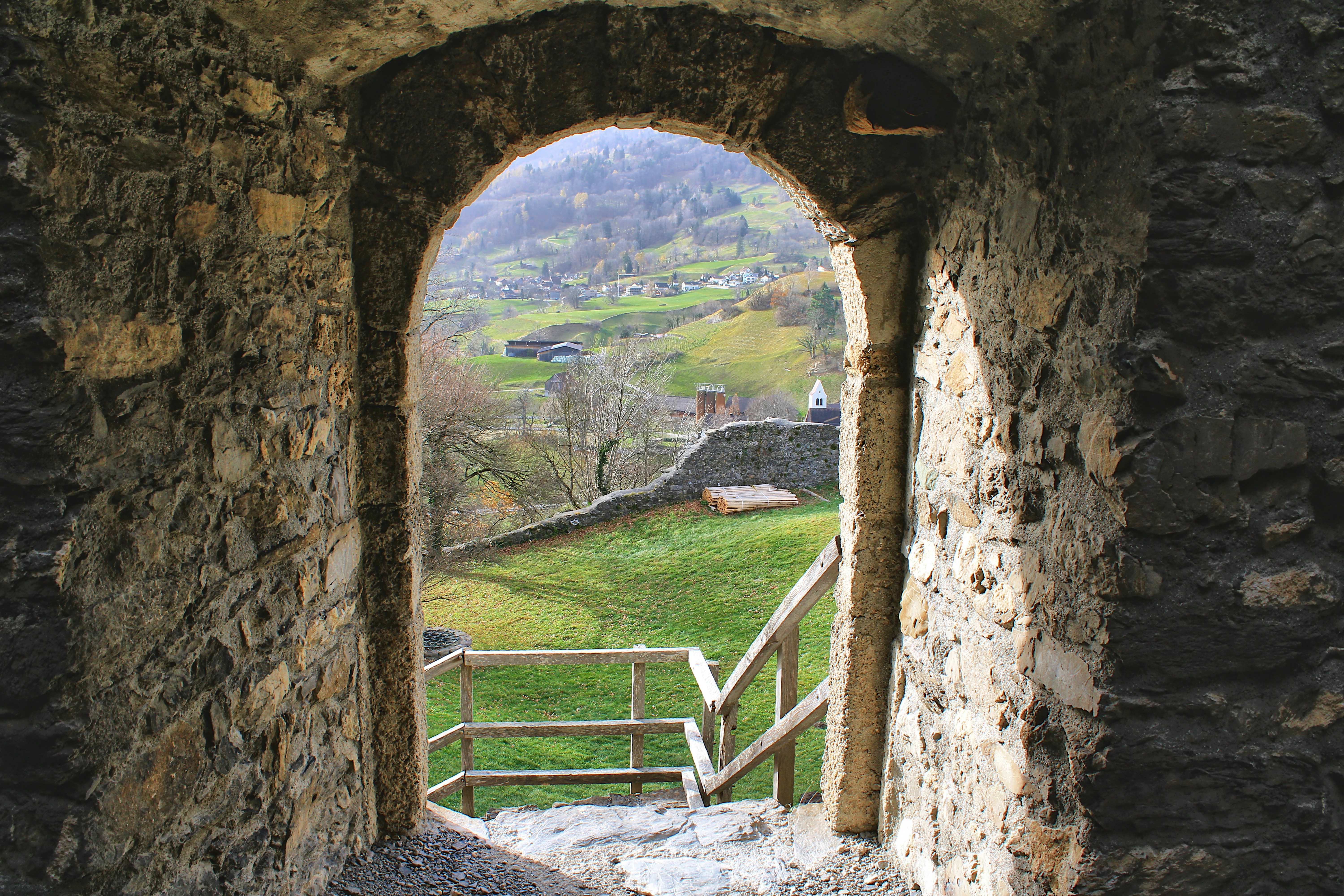 View through stone archway to green valley and hills