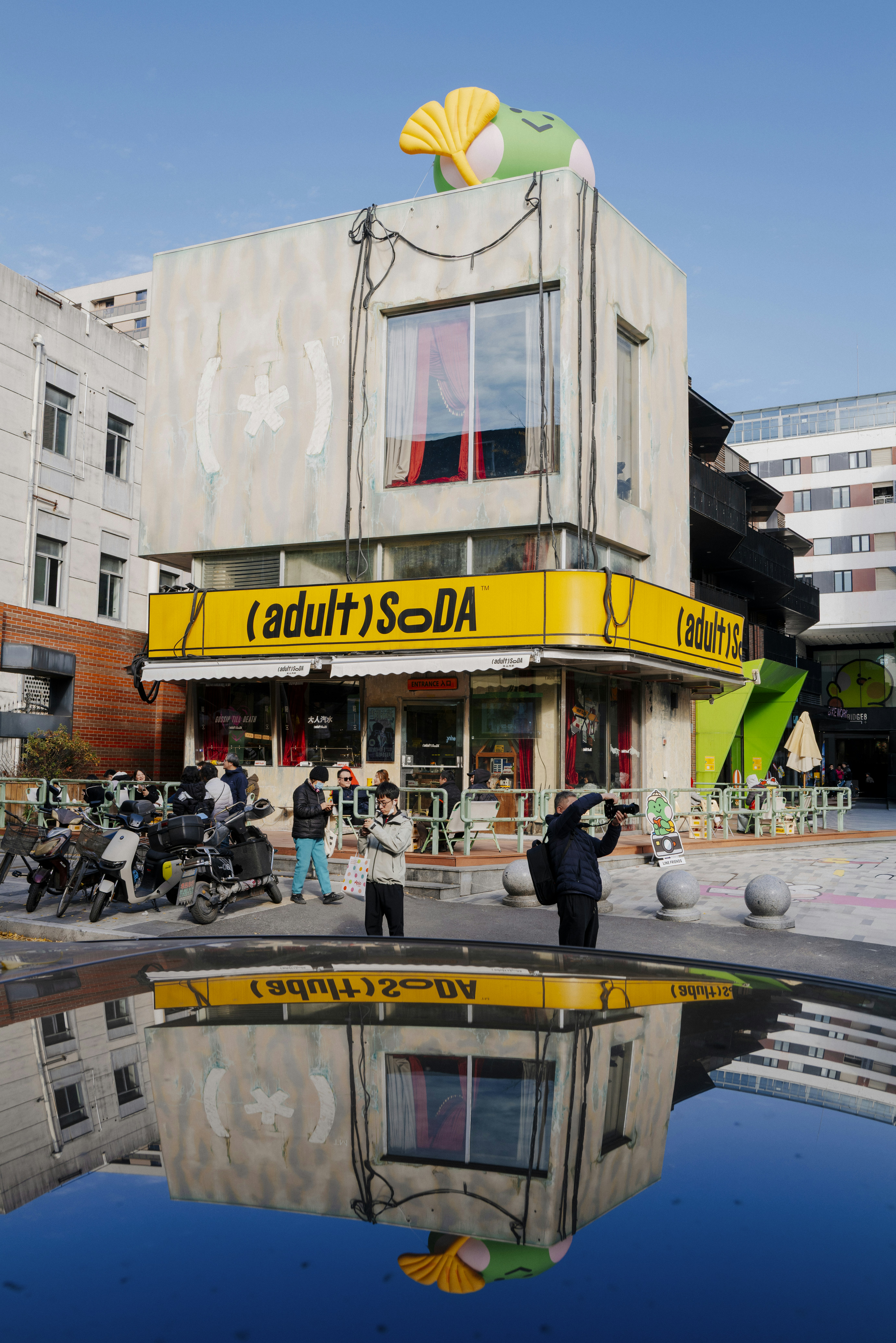 Building with yellow awning and reflection in water