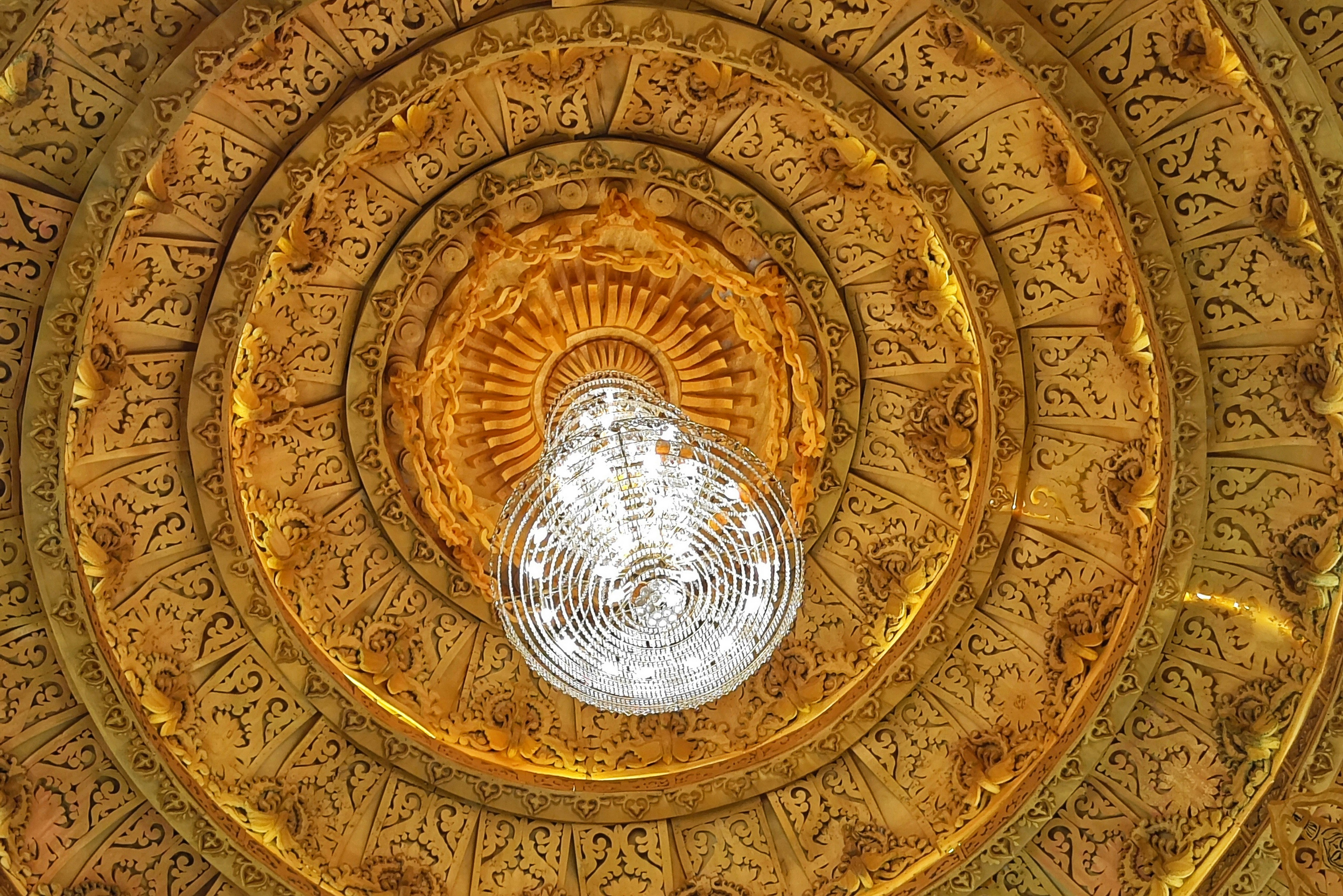 A decorative ceiling with a crystal chandelier.