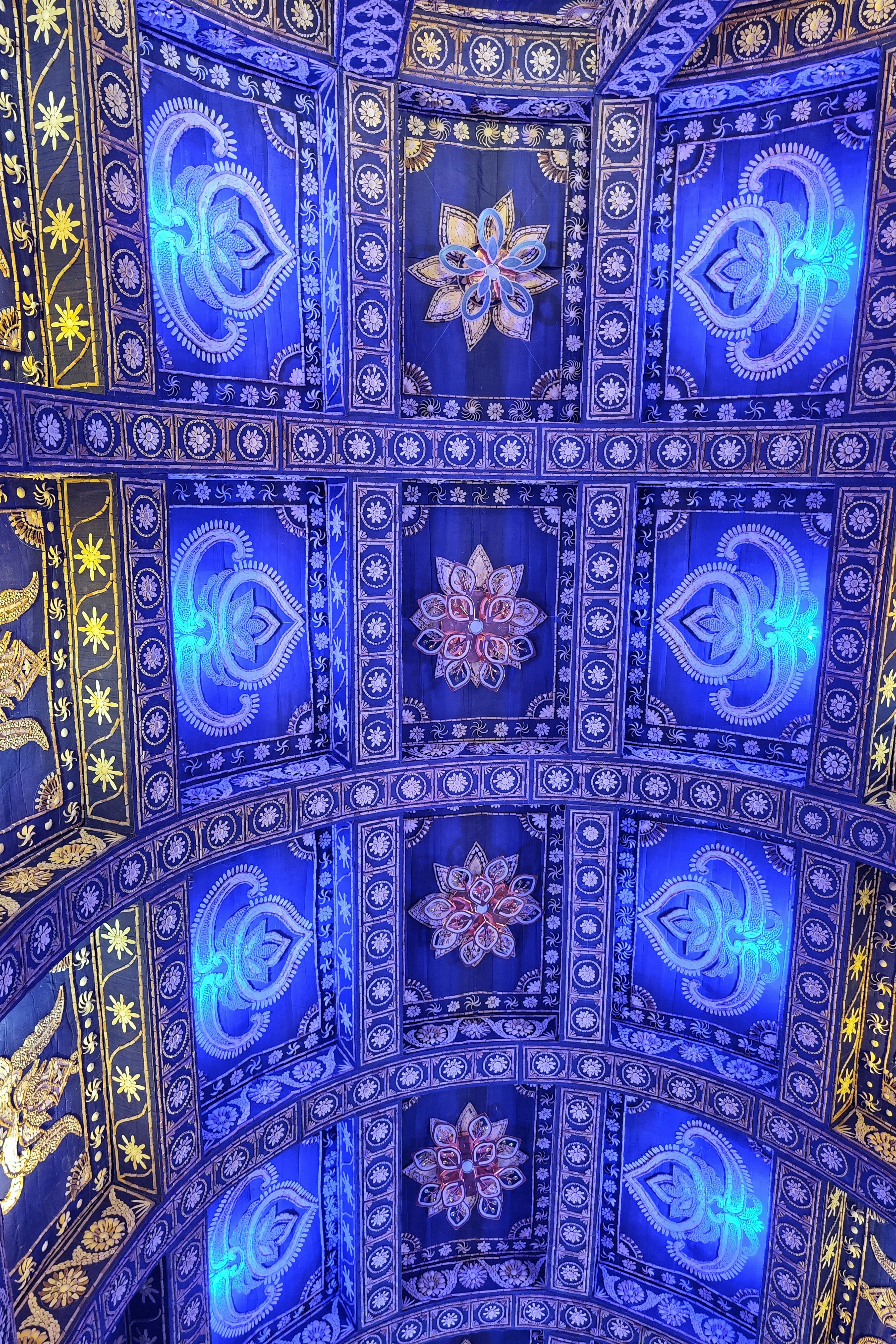 Ornate blue ceiling with golden accents and floral designs.
