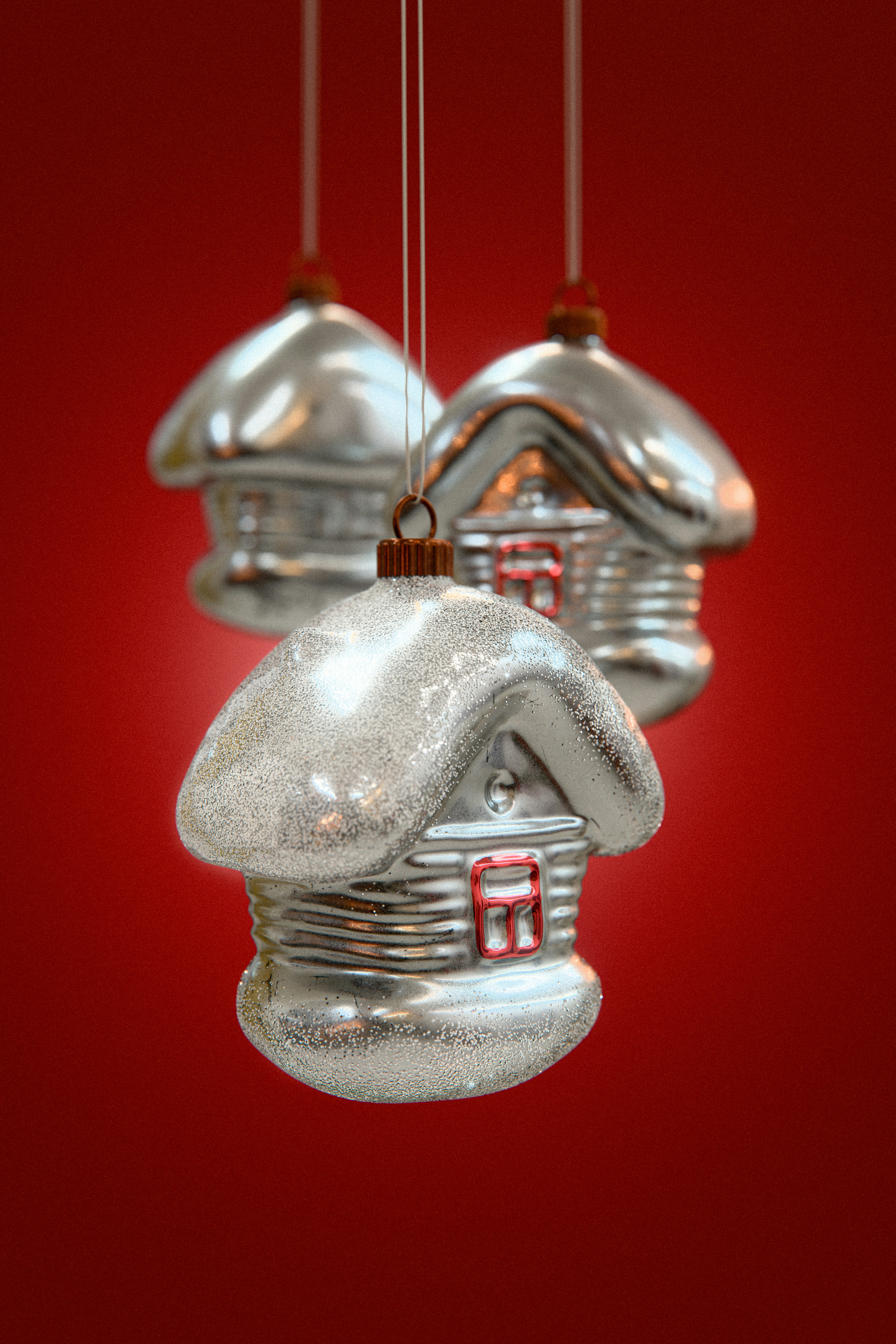 Three silver house christmas ornaments hanging