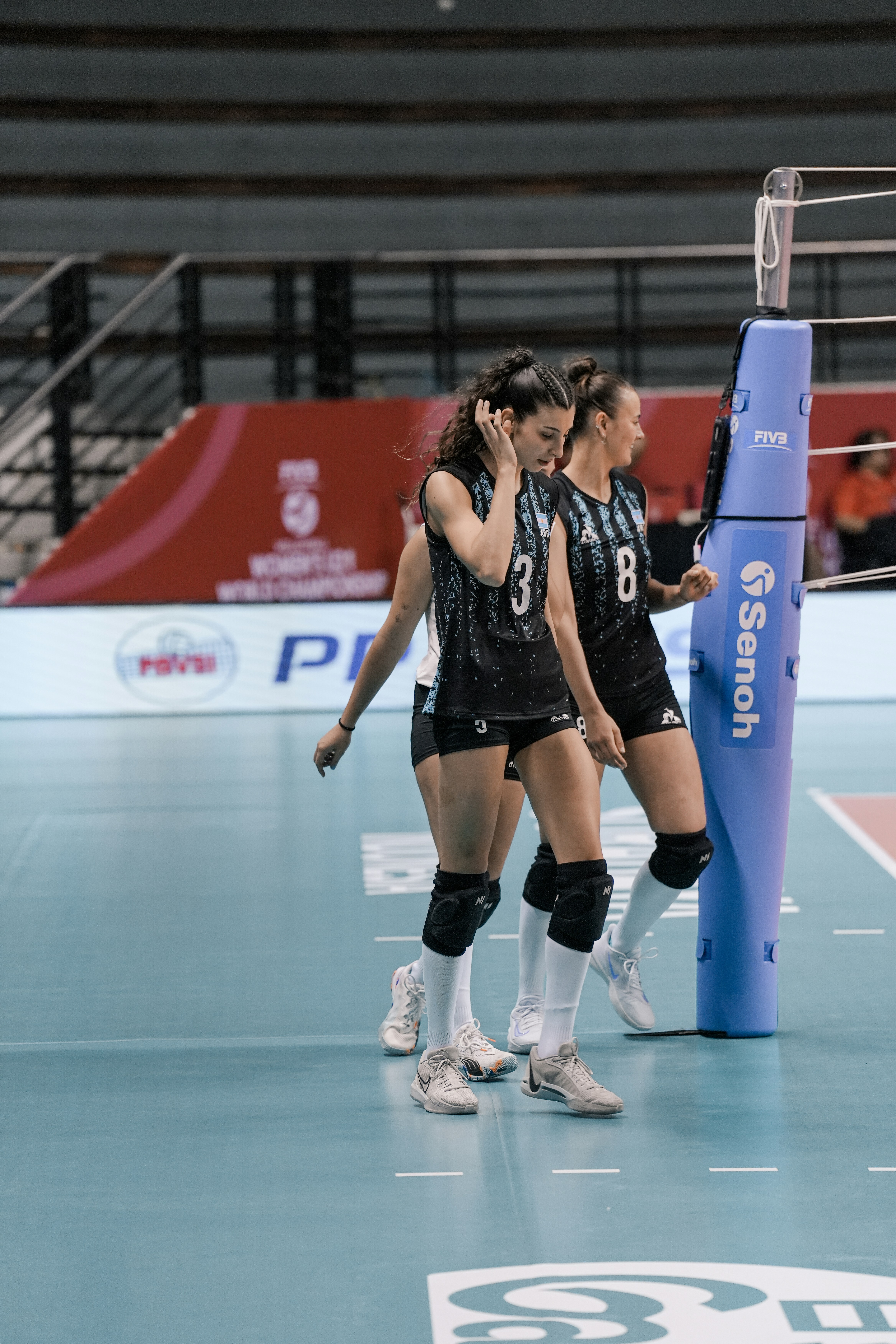 Volleyball players on a court during a match.