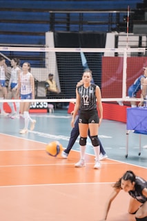 Young female volleyball player in action on court.