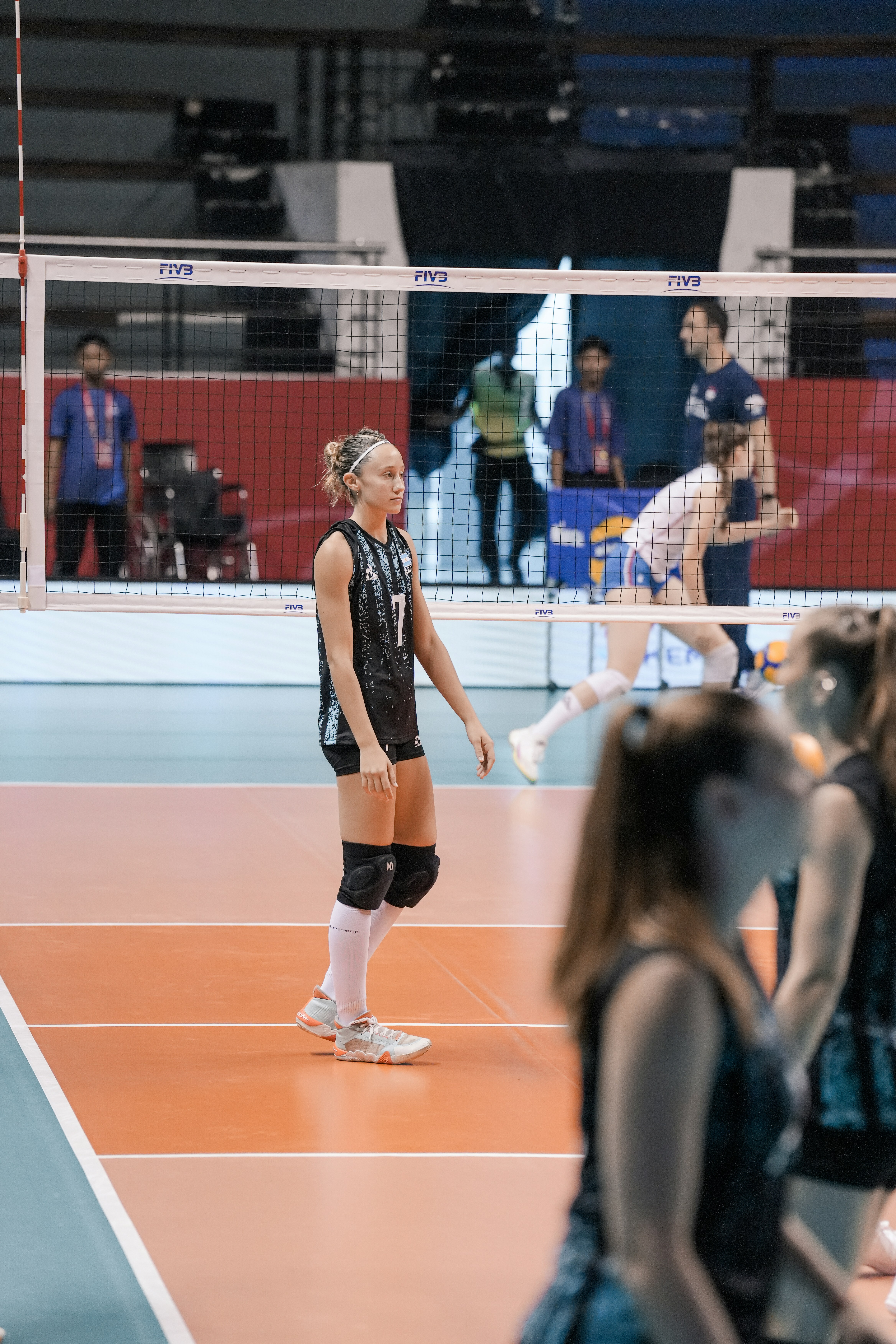 Young woman playing volleyball on indoor court