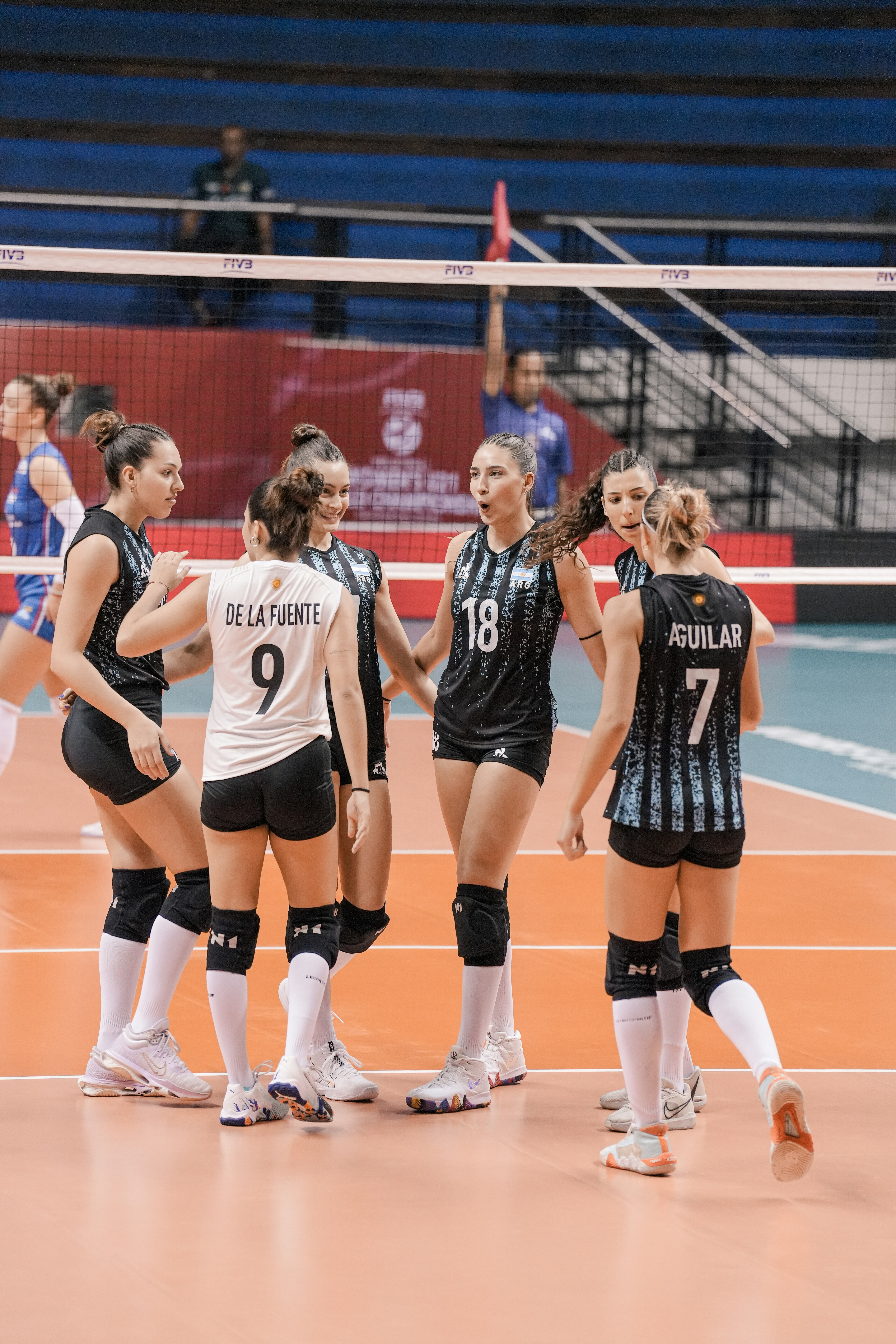 Volleyball players huddle together during a game.