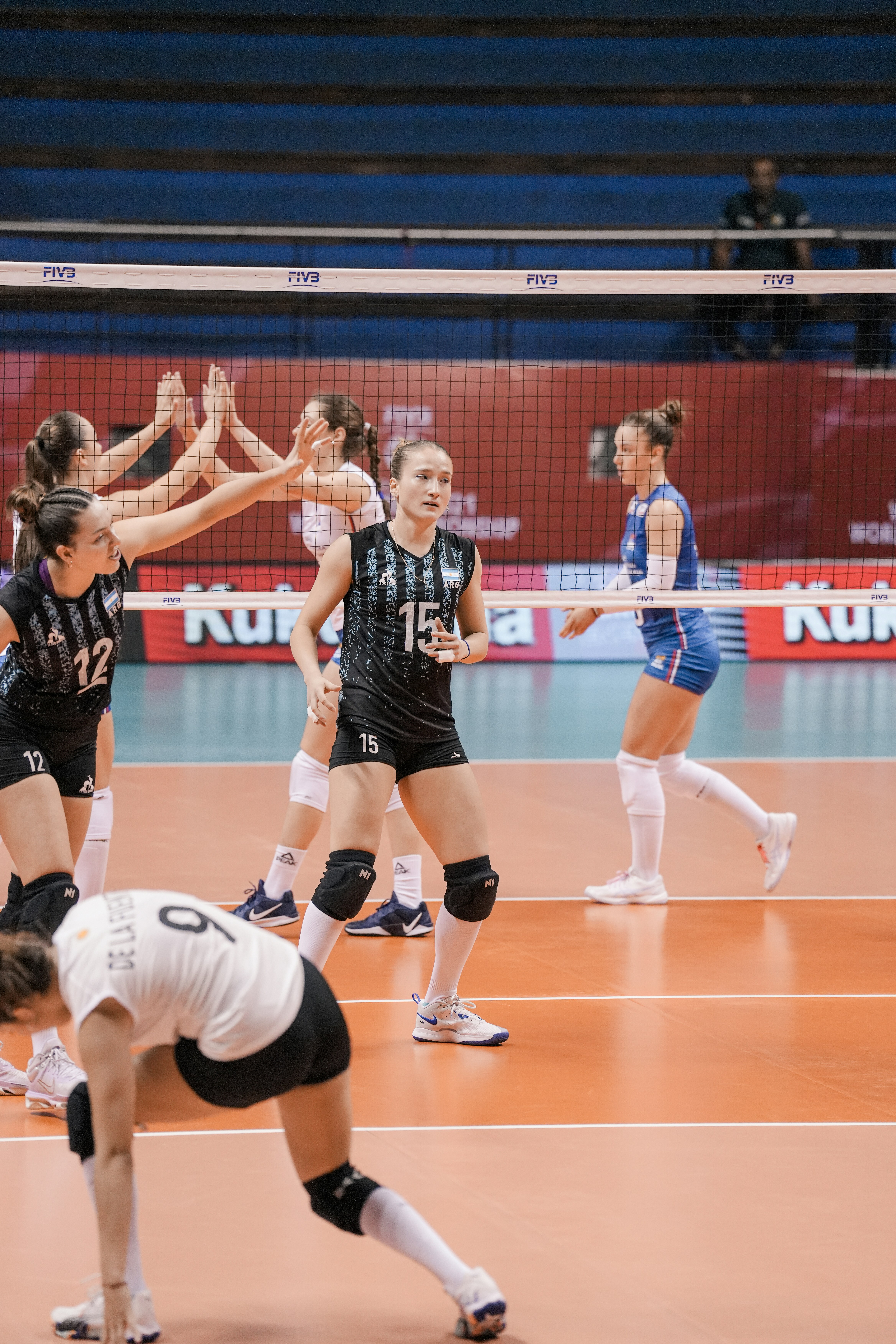 Volleyball players celebrating a point on the court