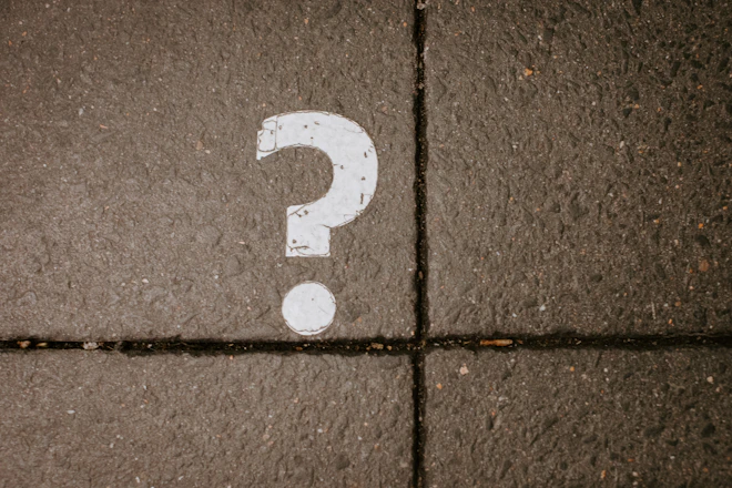 White question mark painted on concrete pavement