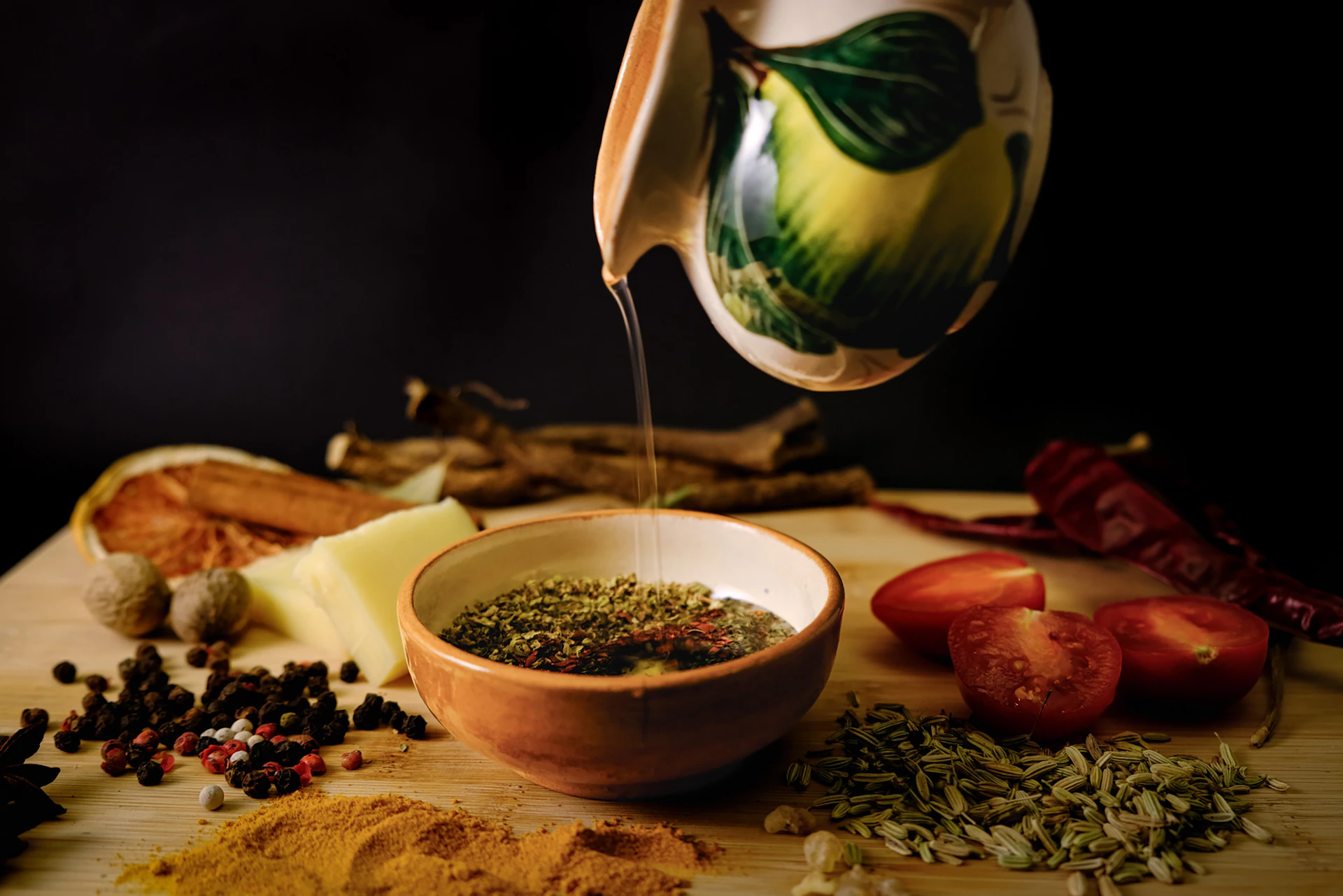 Olive oil being poured into a bowl of herbs