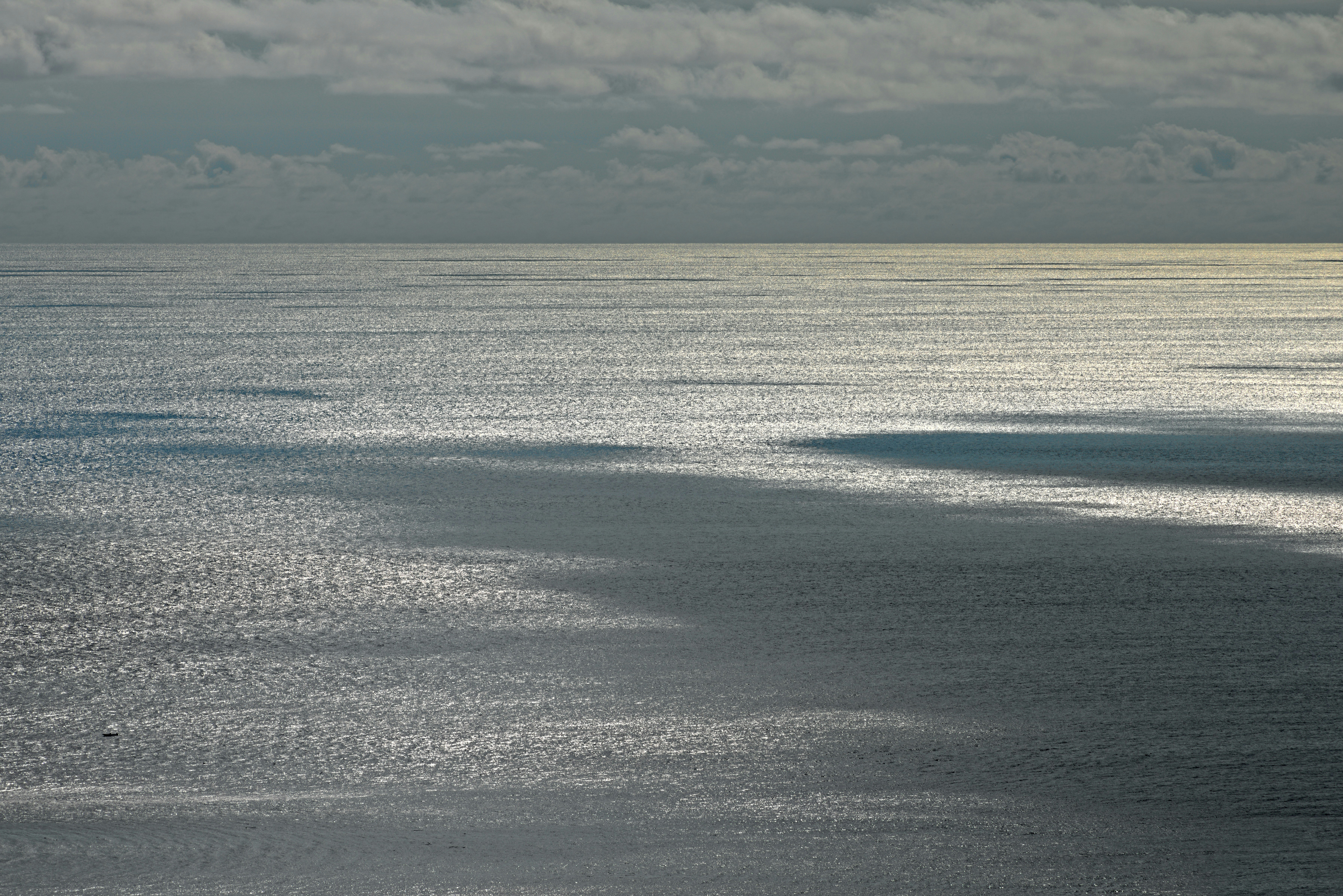 Sunlight reflects on the rippling ocean surface.