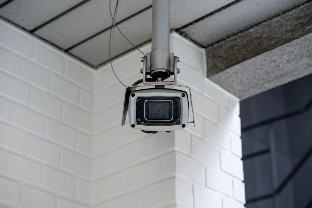 Security camera mounted on a pale brick wall