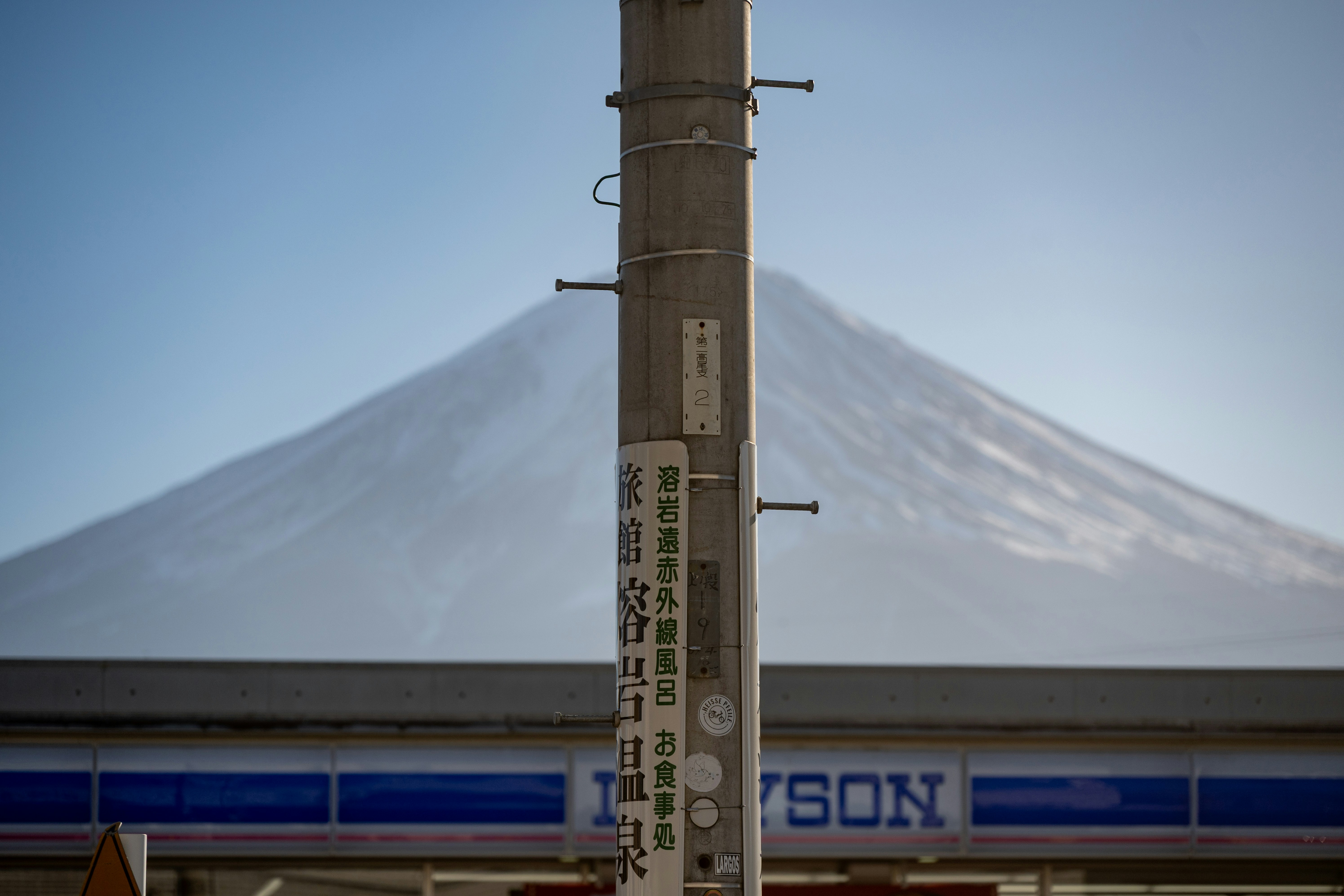 Il monte Fuji dietro un palo e un edificio.