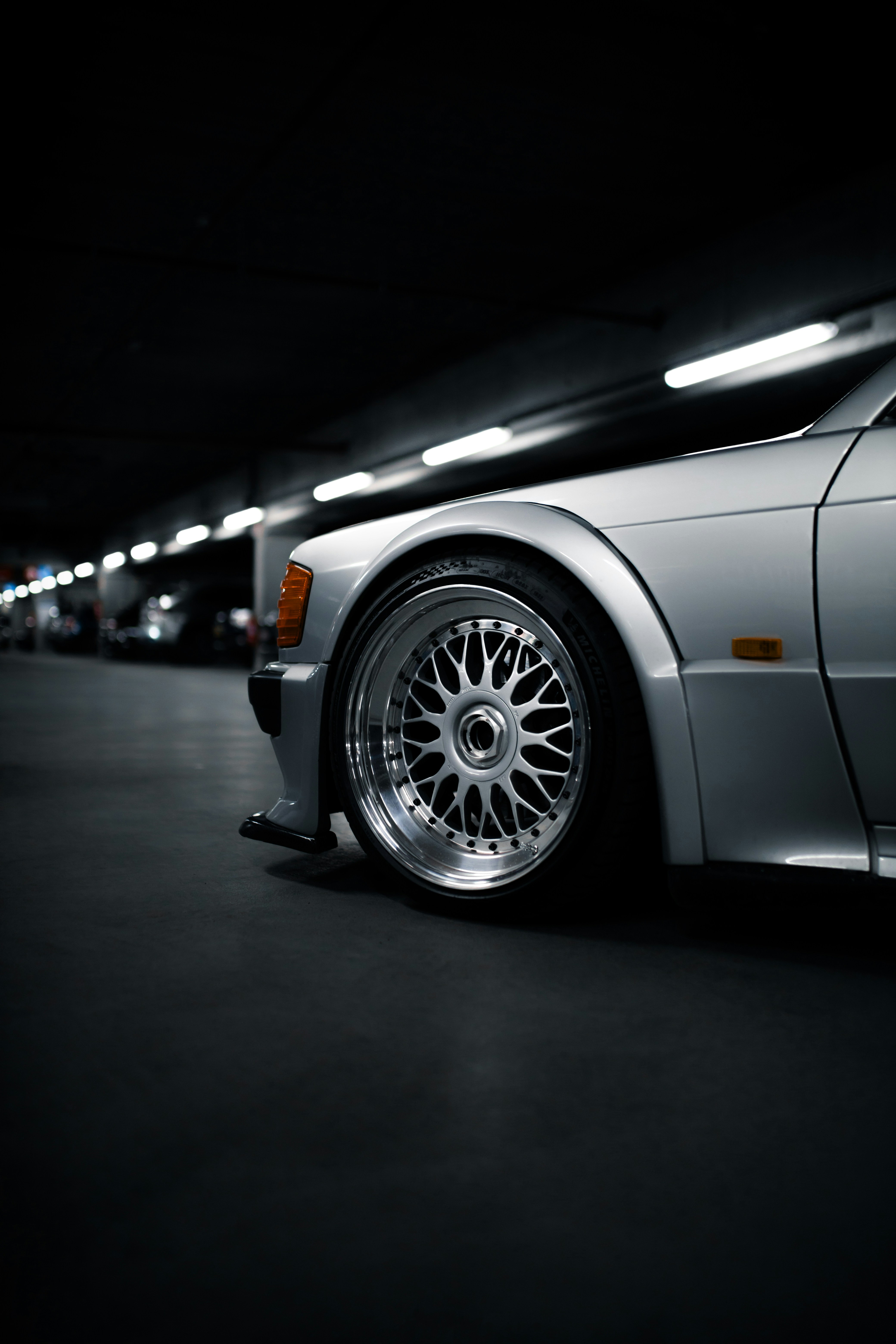 Silver luxury car parked in a dark garage
