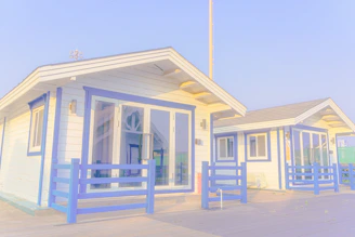 Two white beach houses with blue trim and purple trim.