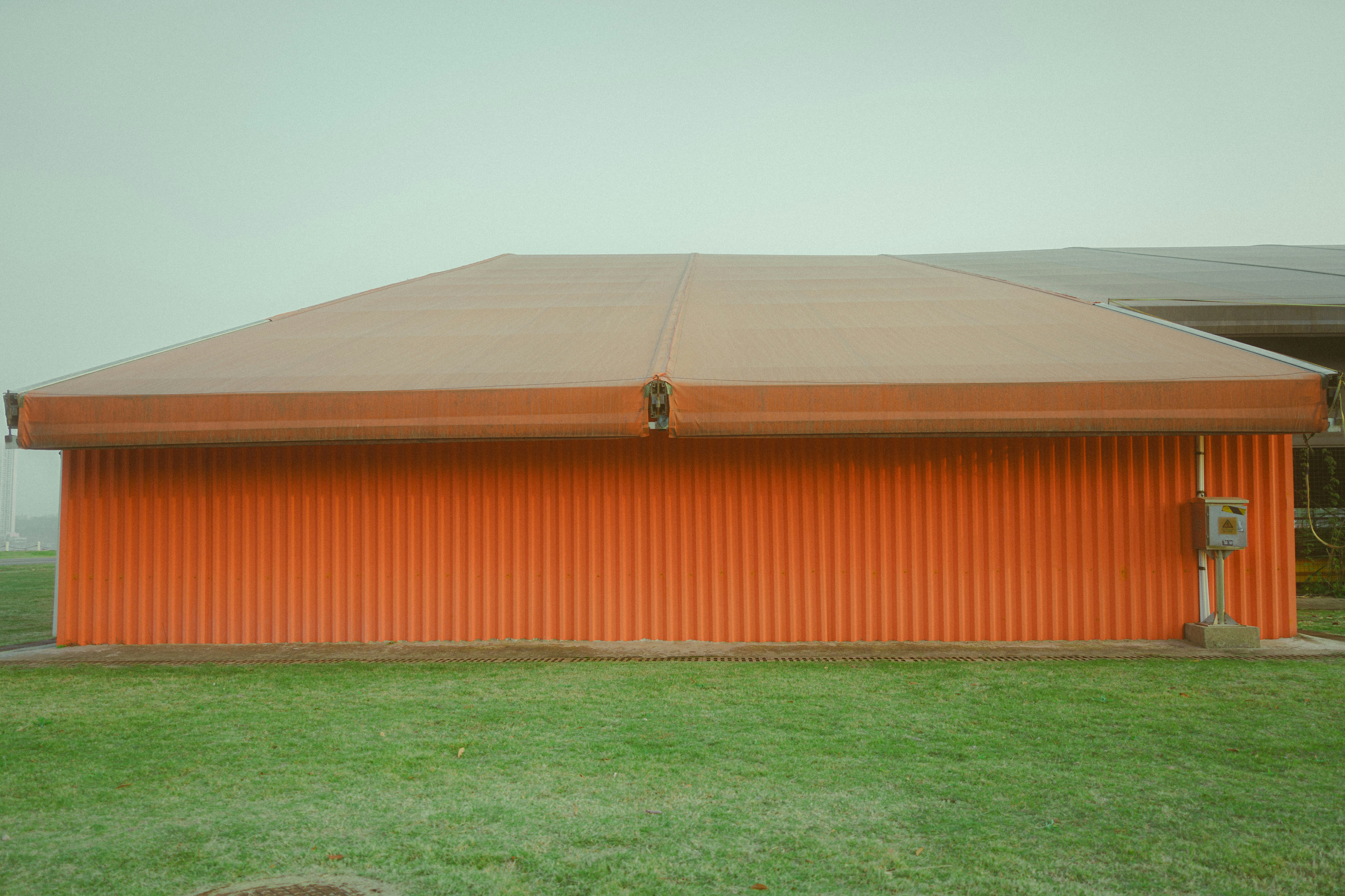Orange corrugated building with a brown awning.