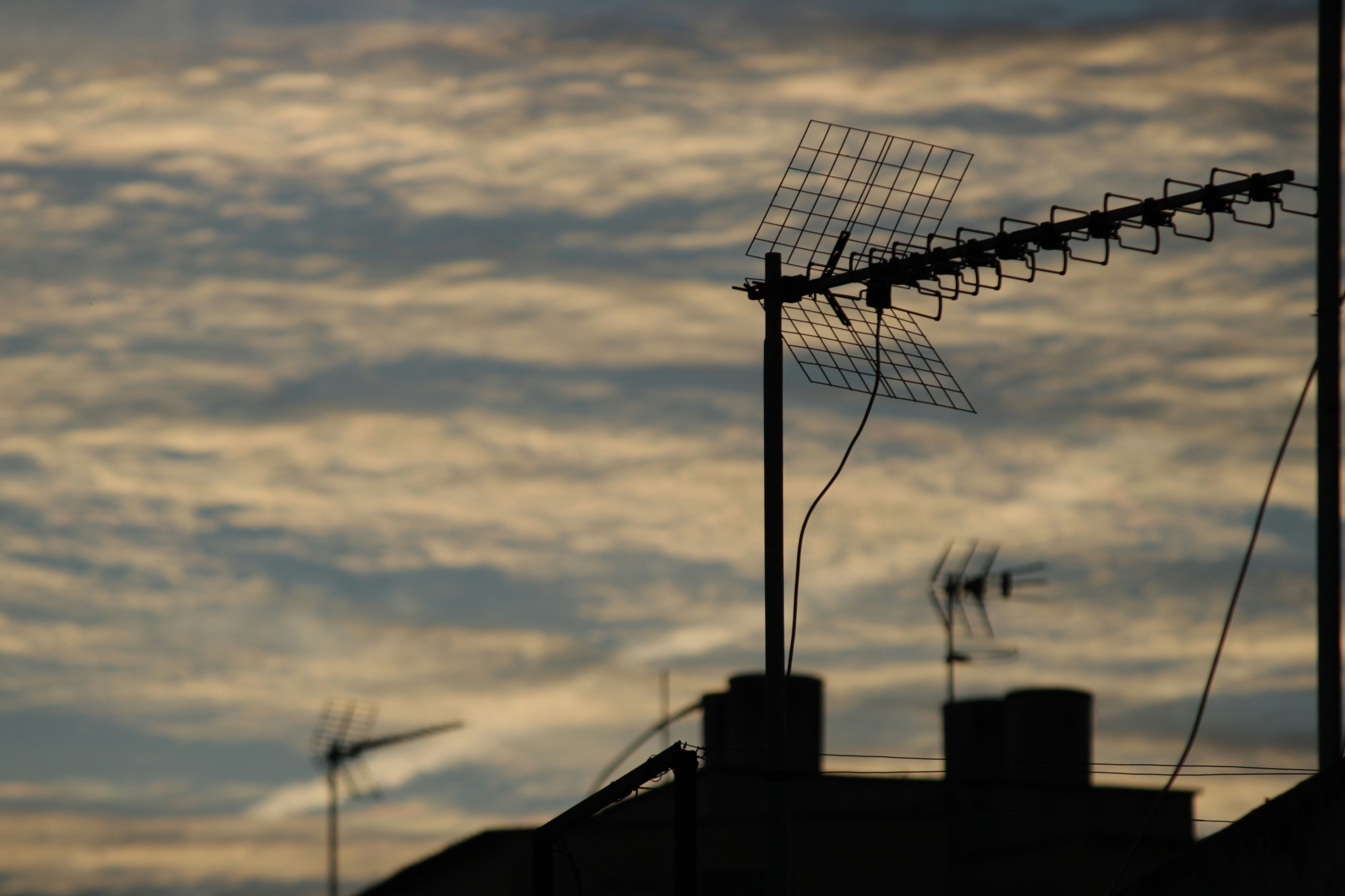 Silhouette of antennas against a cloudy sky