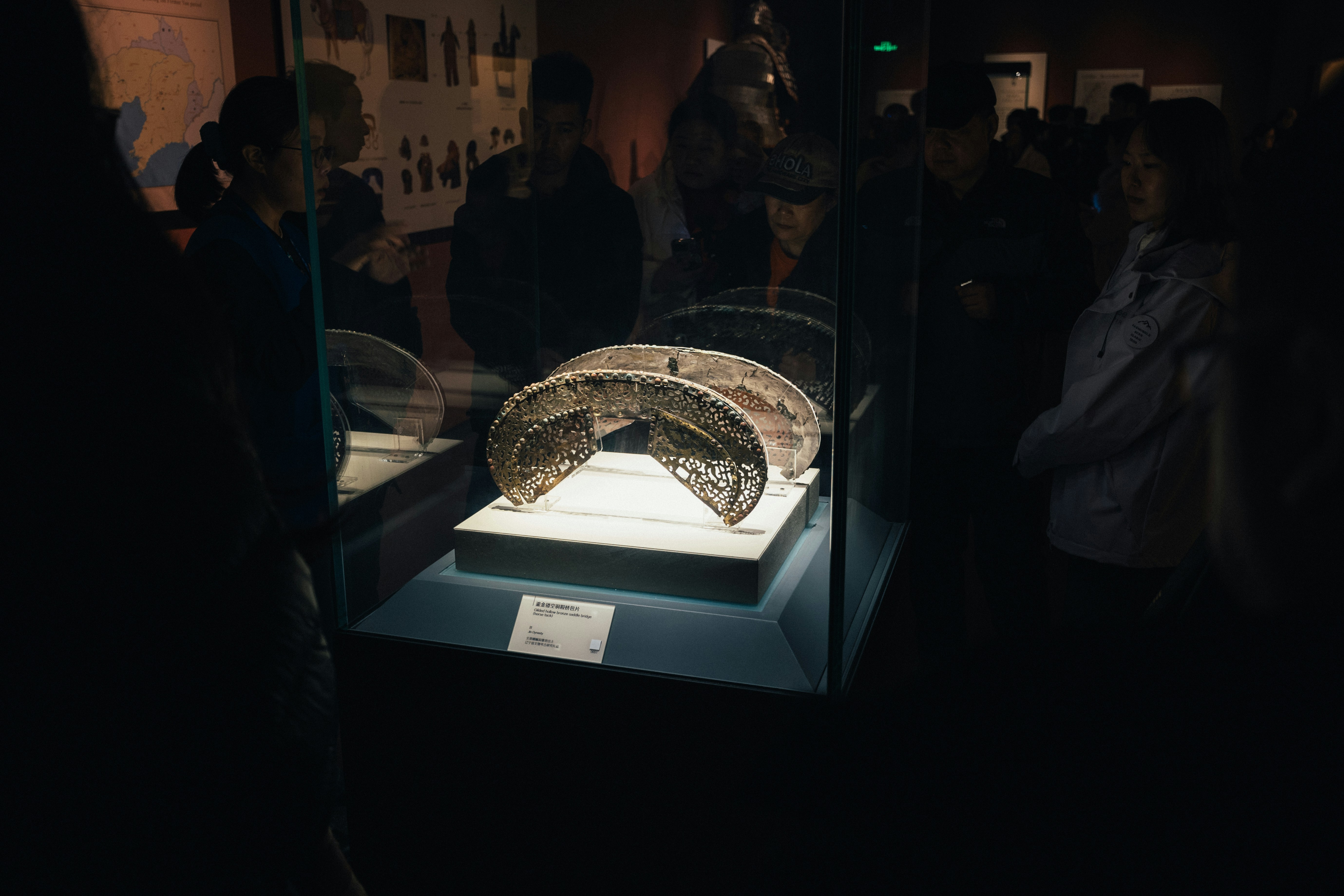 People looking at an artifact in a museum exhibit.