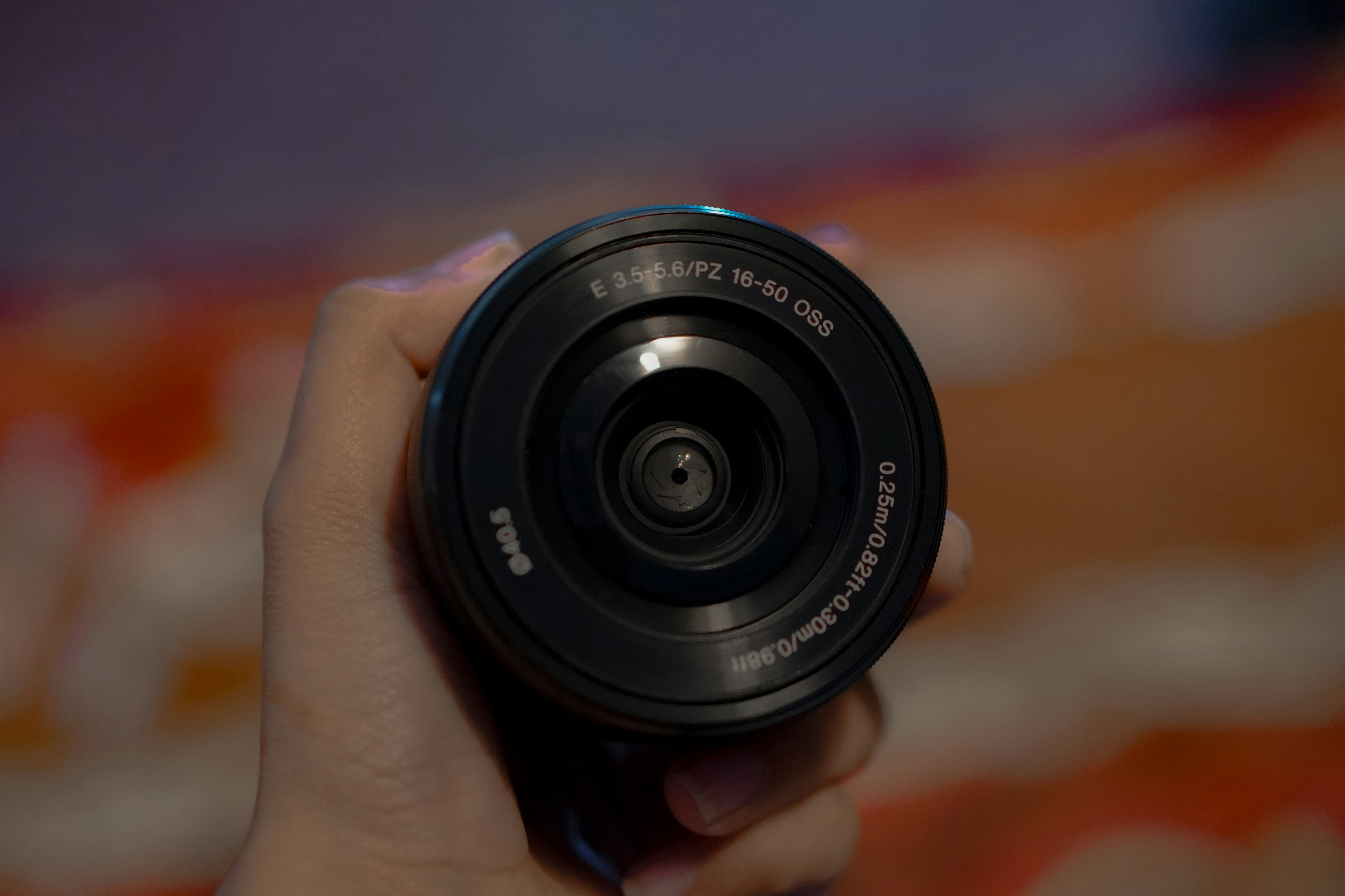 A hand holding a camera lens