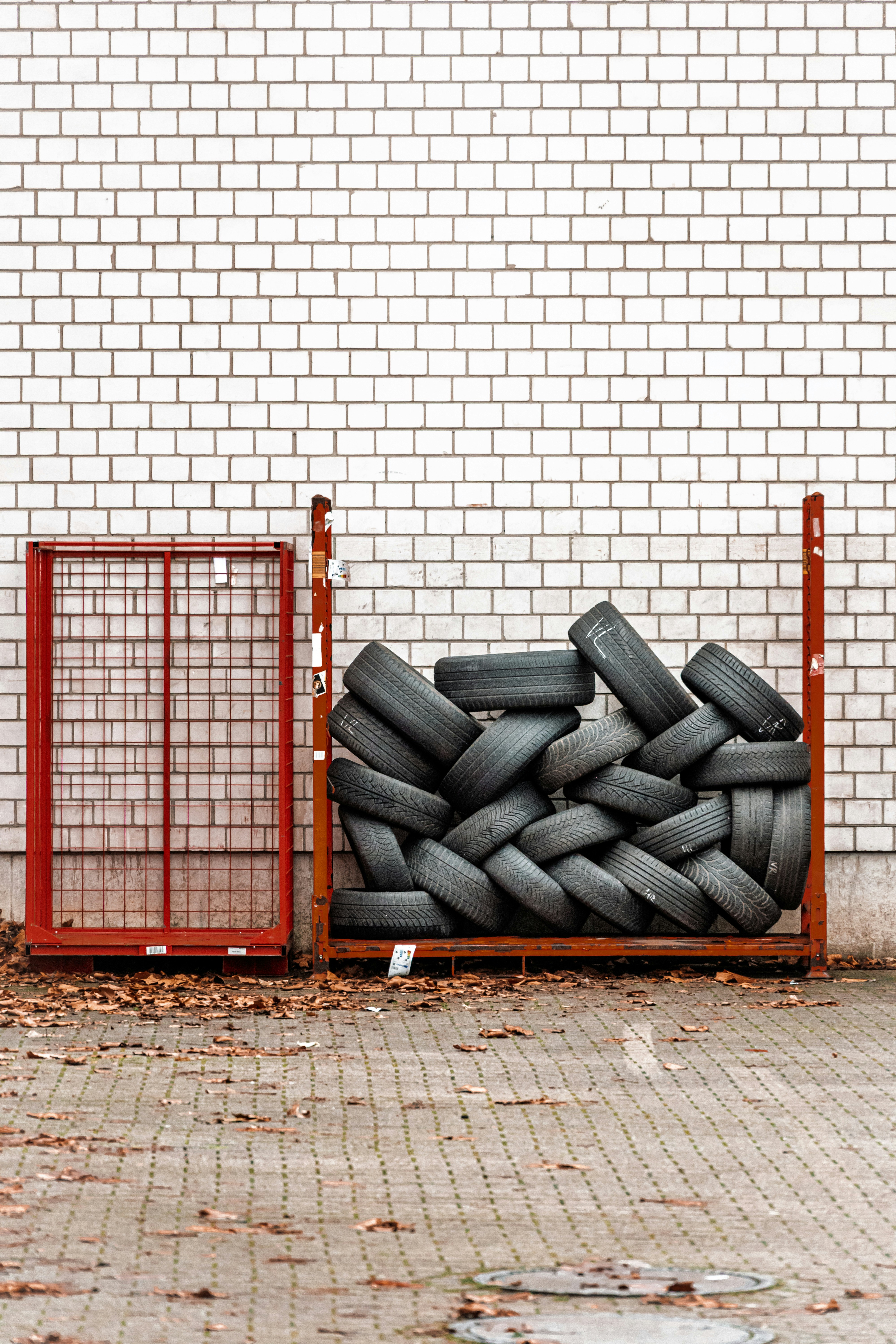 Stack of tires in a metal rack near wall